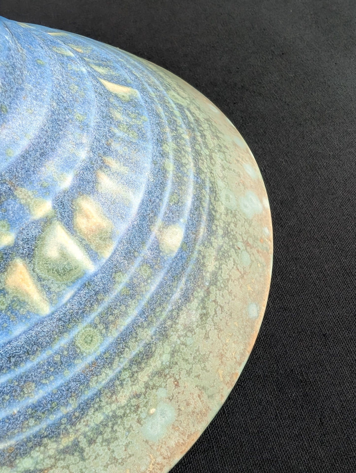 Close up of the outside rim of matte green and blue crystalline ring dish by Robbin Harris.