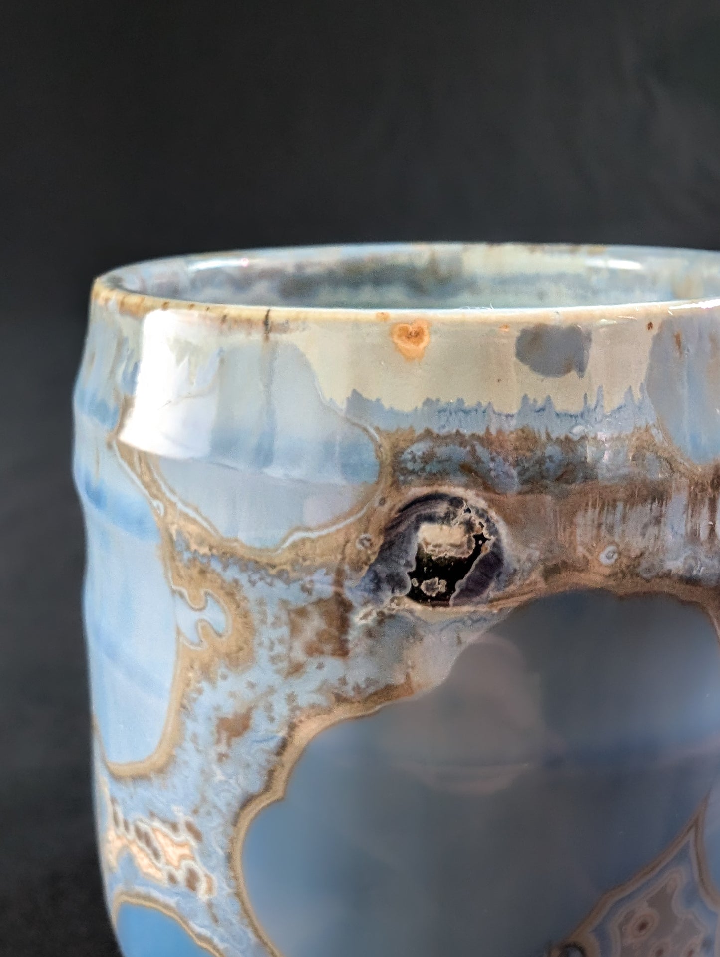 Close-up of the pressed drum key maker’s mark near the top edge and soft reflections in the glossy glaze.