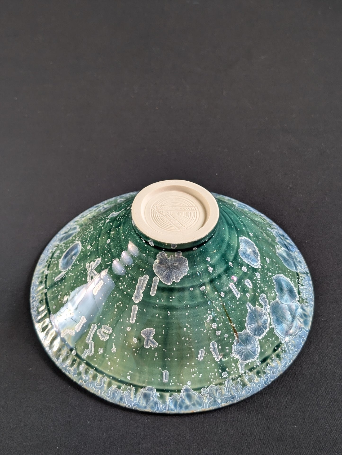 Outside view of emerald green ring dish with sapphire blue crystalline crystals adorning the surface.