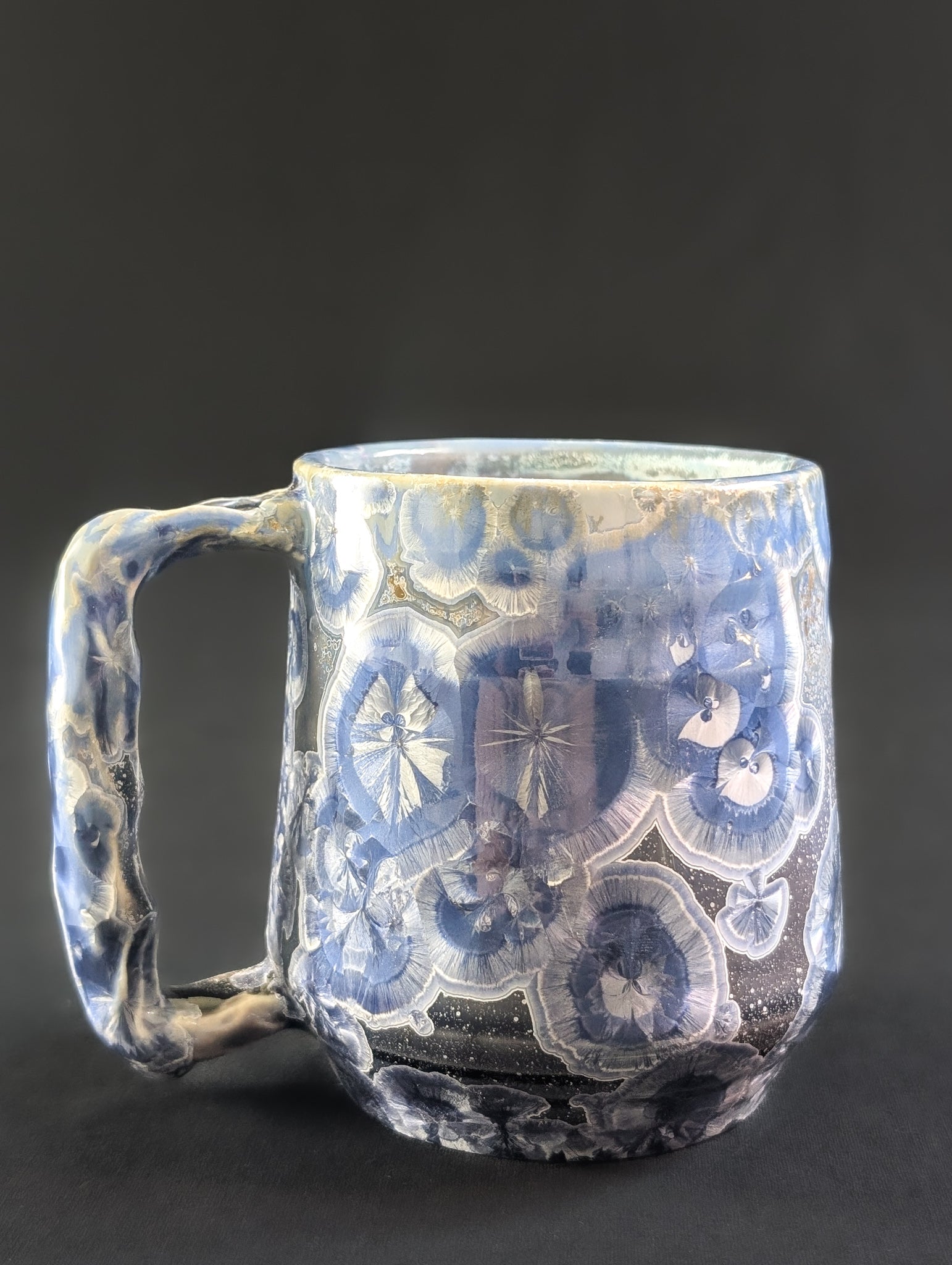 Porcelain mug as seen from the side with blue and white crystals.