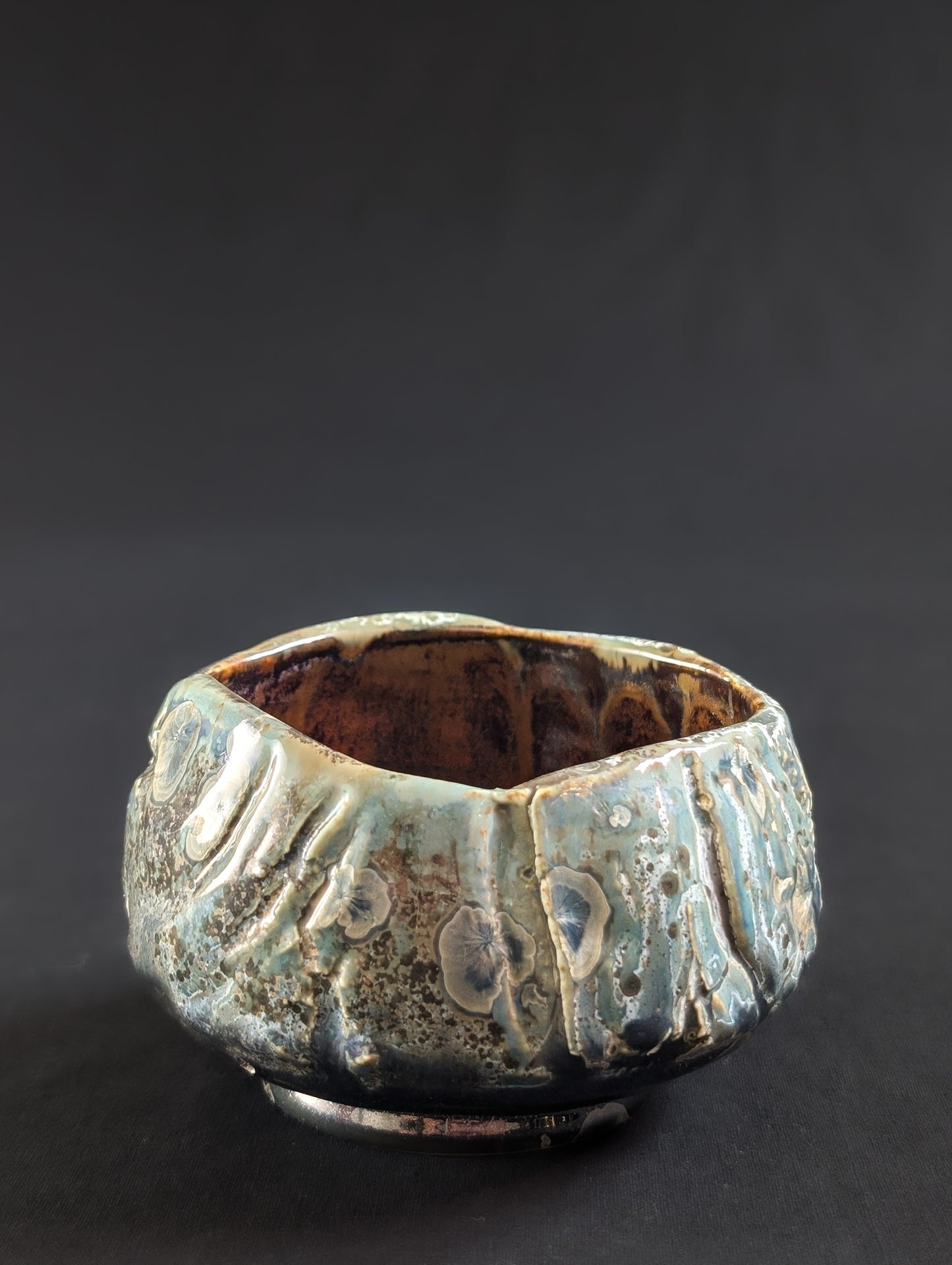 Profile of 'Verdigris', featuring soft green tones, metallic patches, and a subtly uneven rim against a black background.