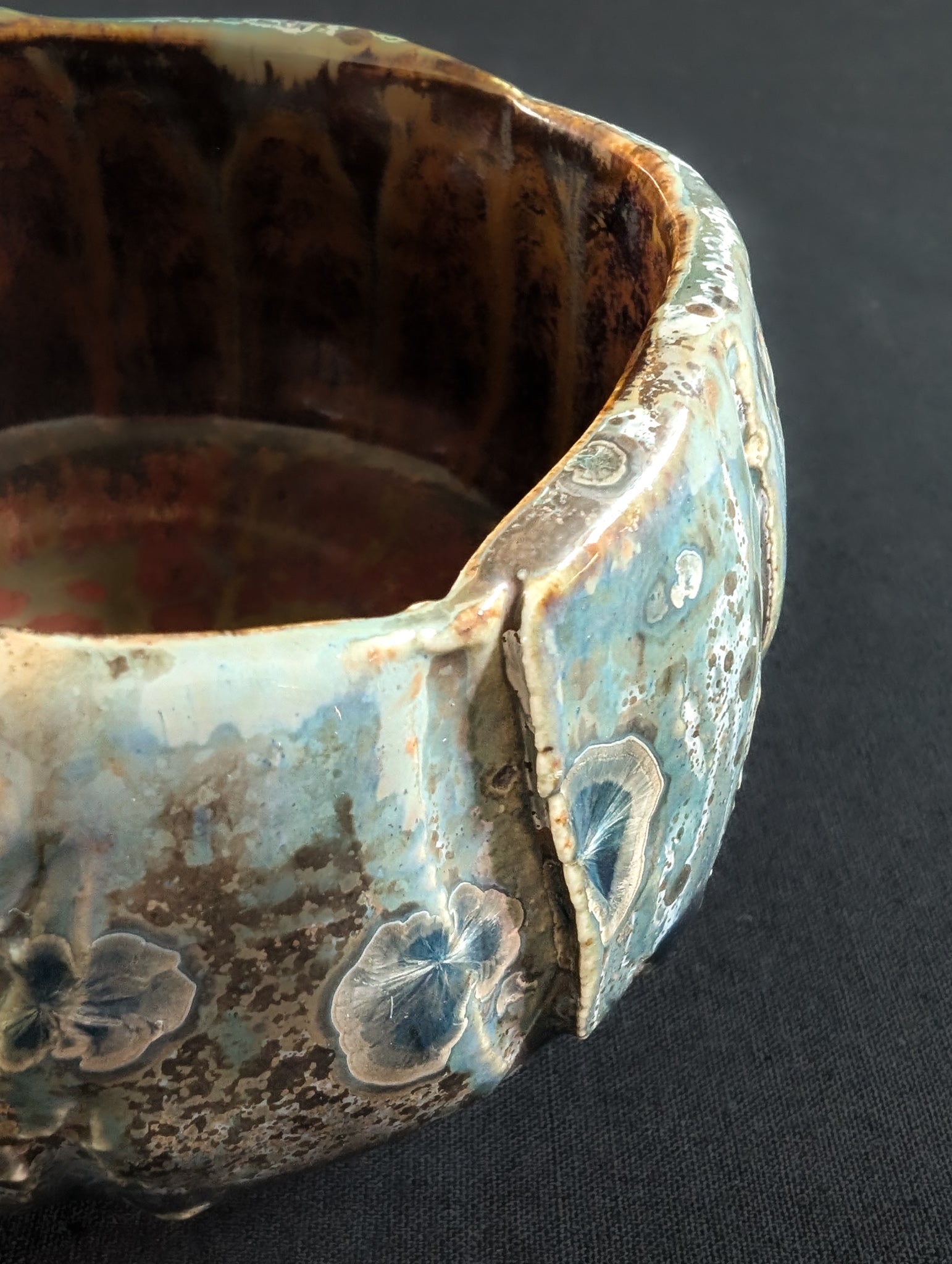 Close-up of 'Verdigris' surface, revealing vertical texturing and a mix of silvery and brown speckled crystals.