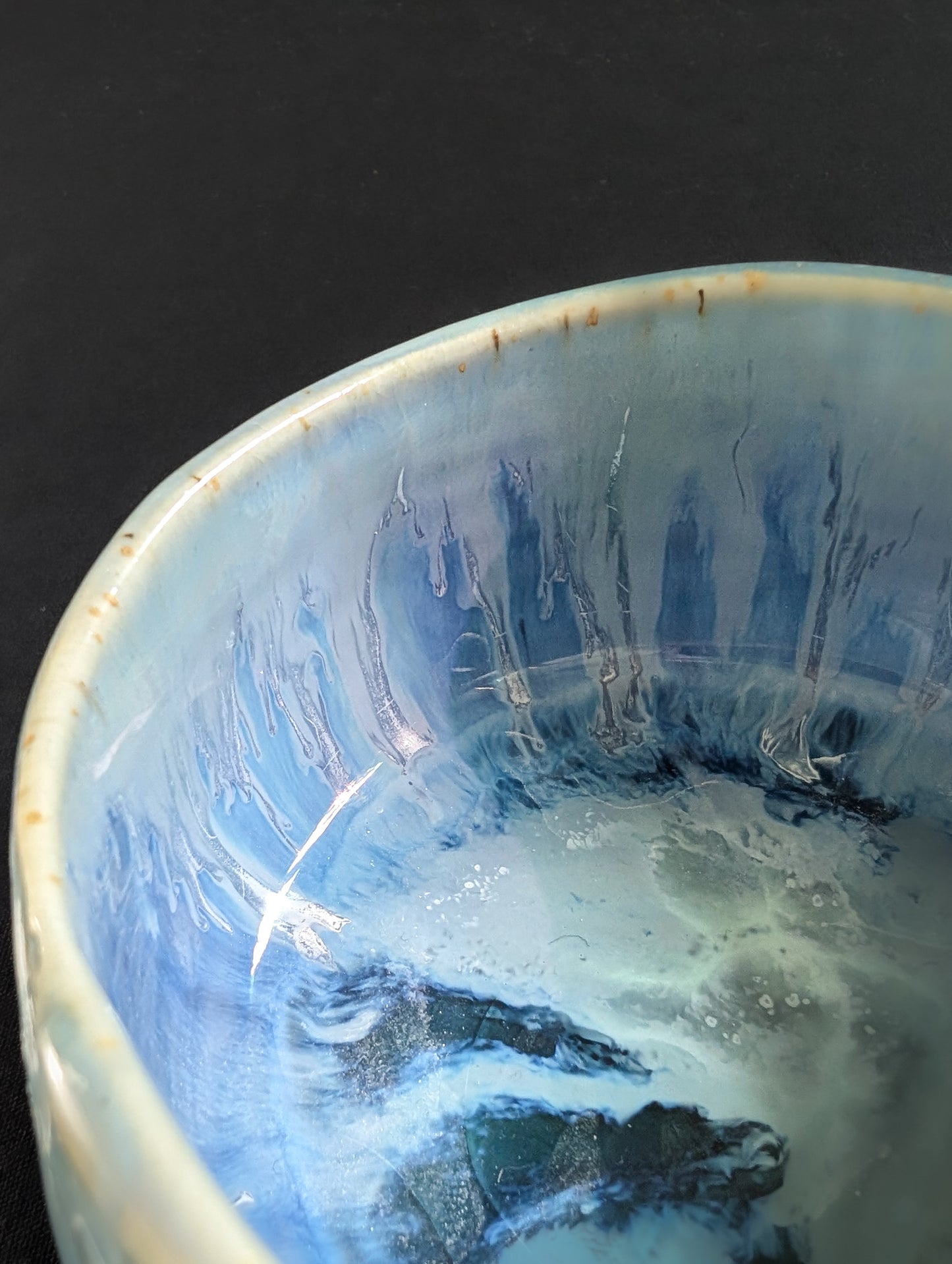 Macro detail of glaze dripping down the side of 'Caldera', with natural curves and layered textures.