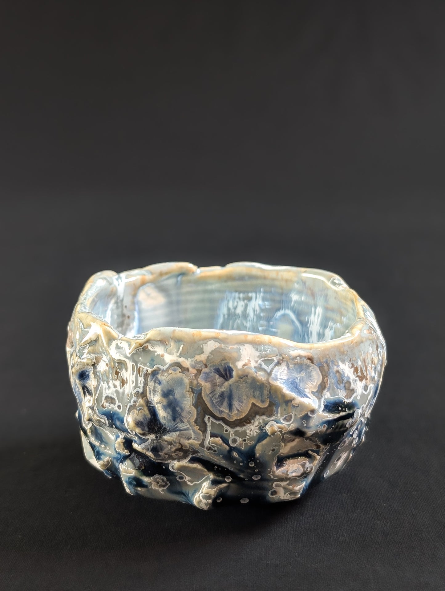 Profile of 'Yukihana' tea bowl, with heavy carving and large, ice-like crystals emerging from the surface.