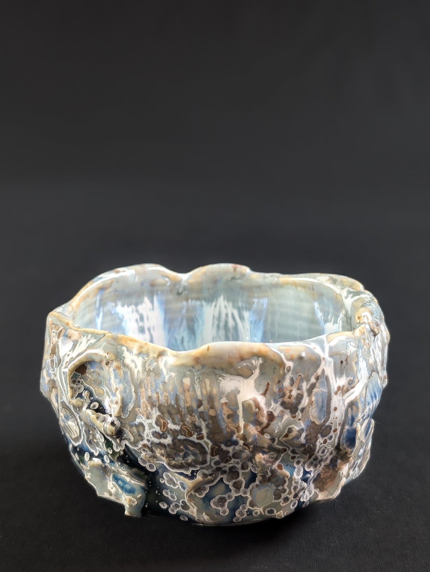 Side view showing strong color gradient from deep blue to soft blue, with crystal formations and rugged glaze flow.
