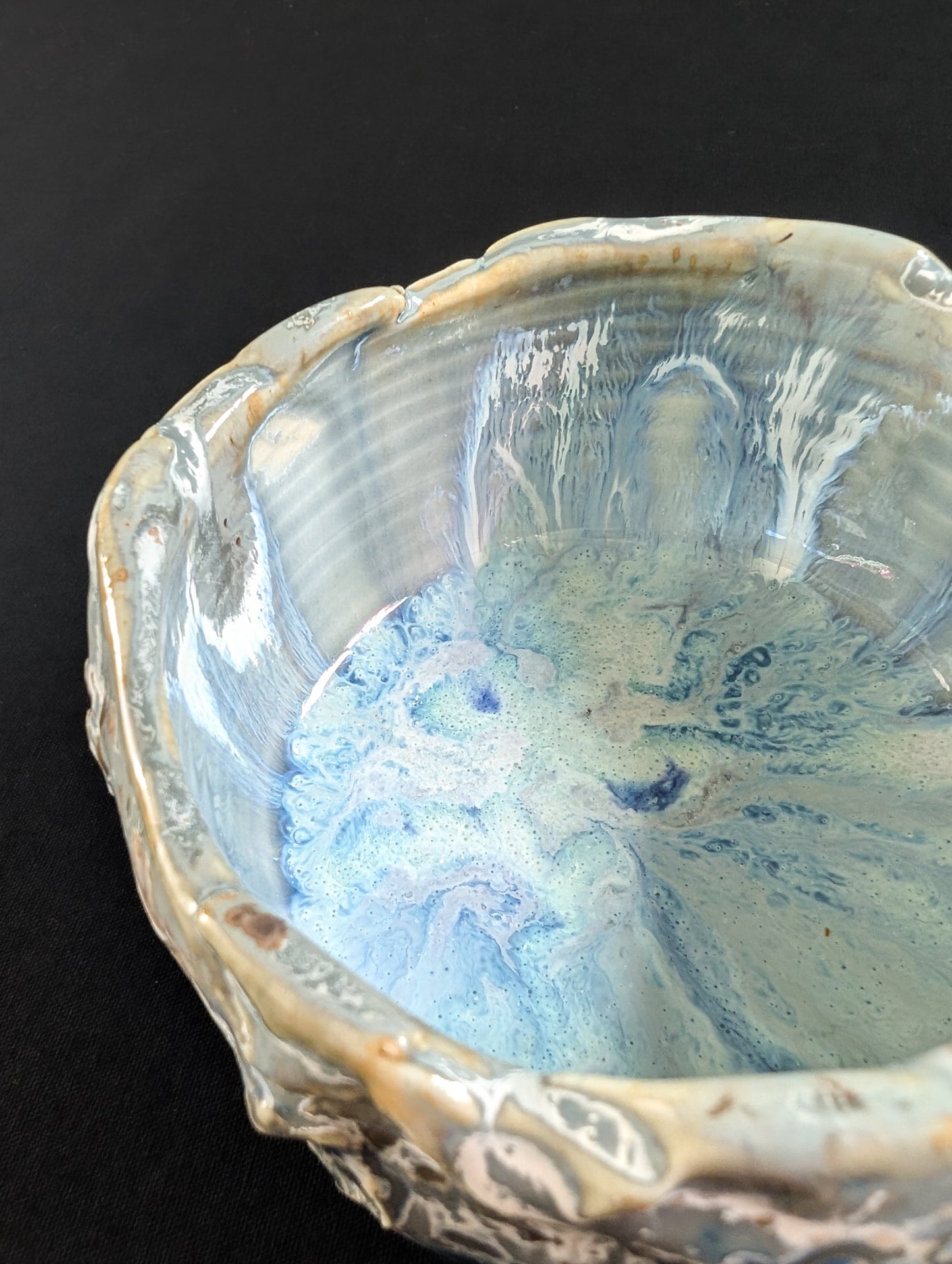 Interior of the tea bowl showing soft ripples and pale glaze layers flowing gently from the rim.