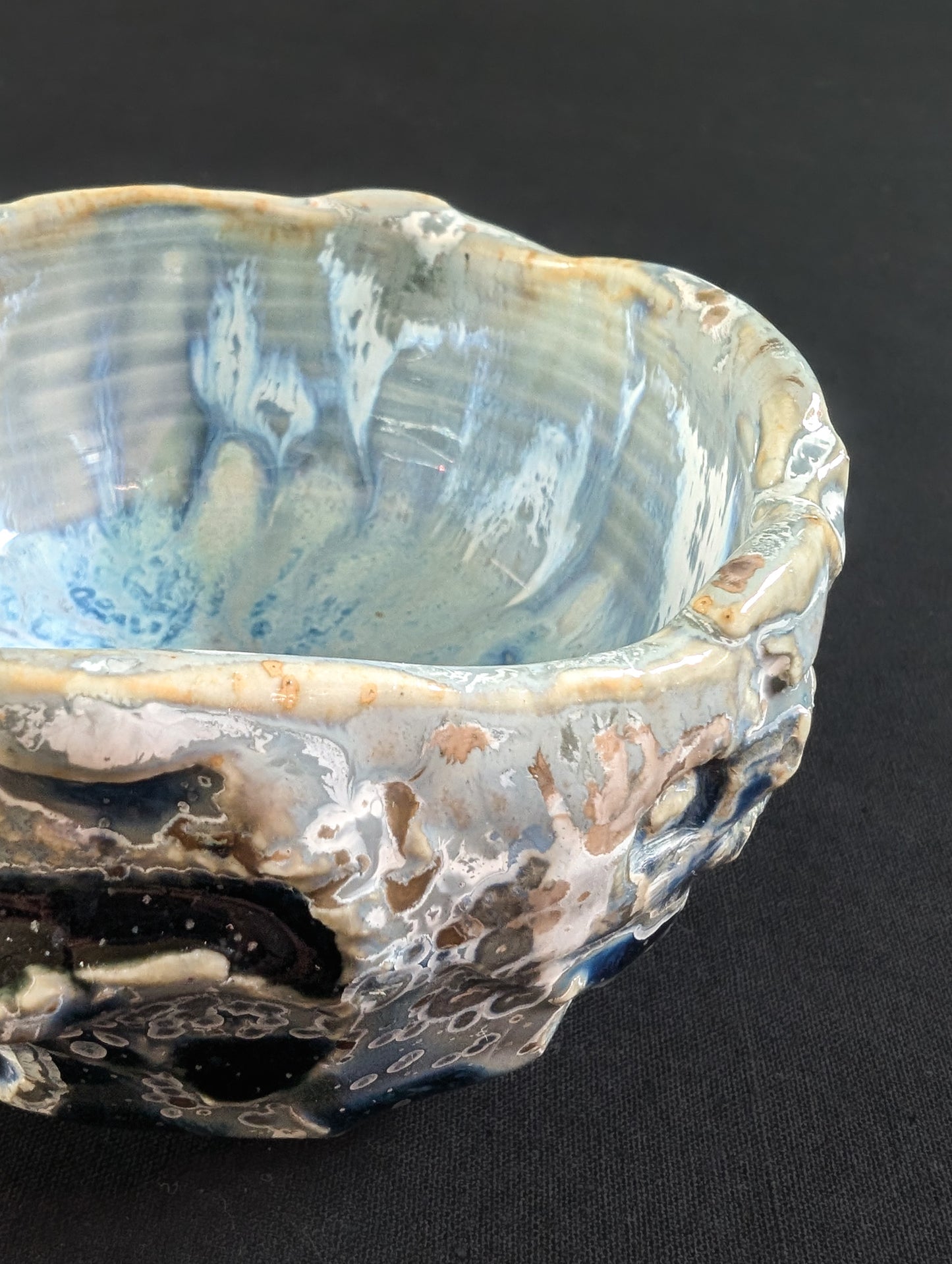 Texture detail from 'Icewake', where heavy glaze meets crystalline growth in shimmering blues and earthy rings.