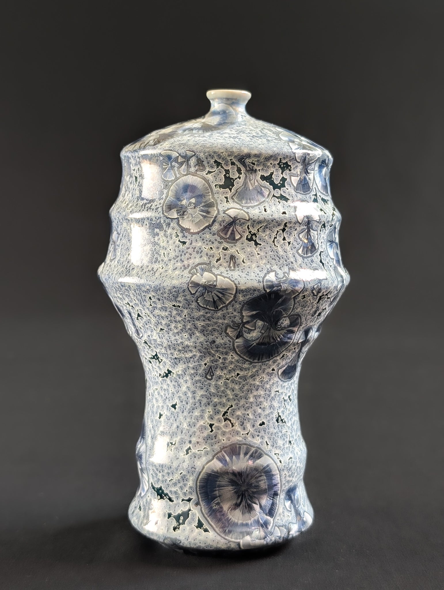 Ceramic vase with small and large crystals on a dark background
