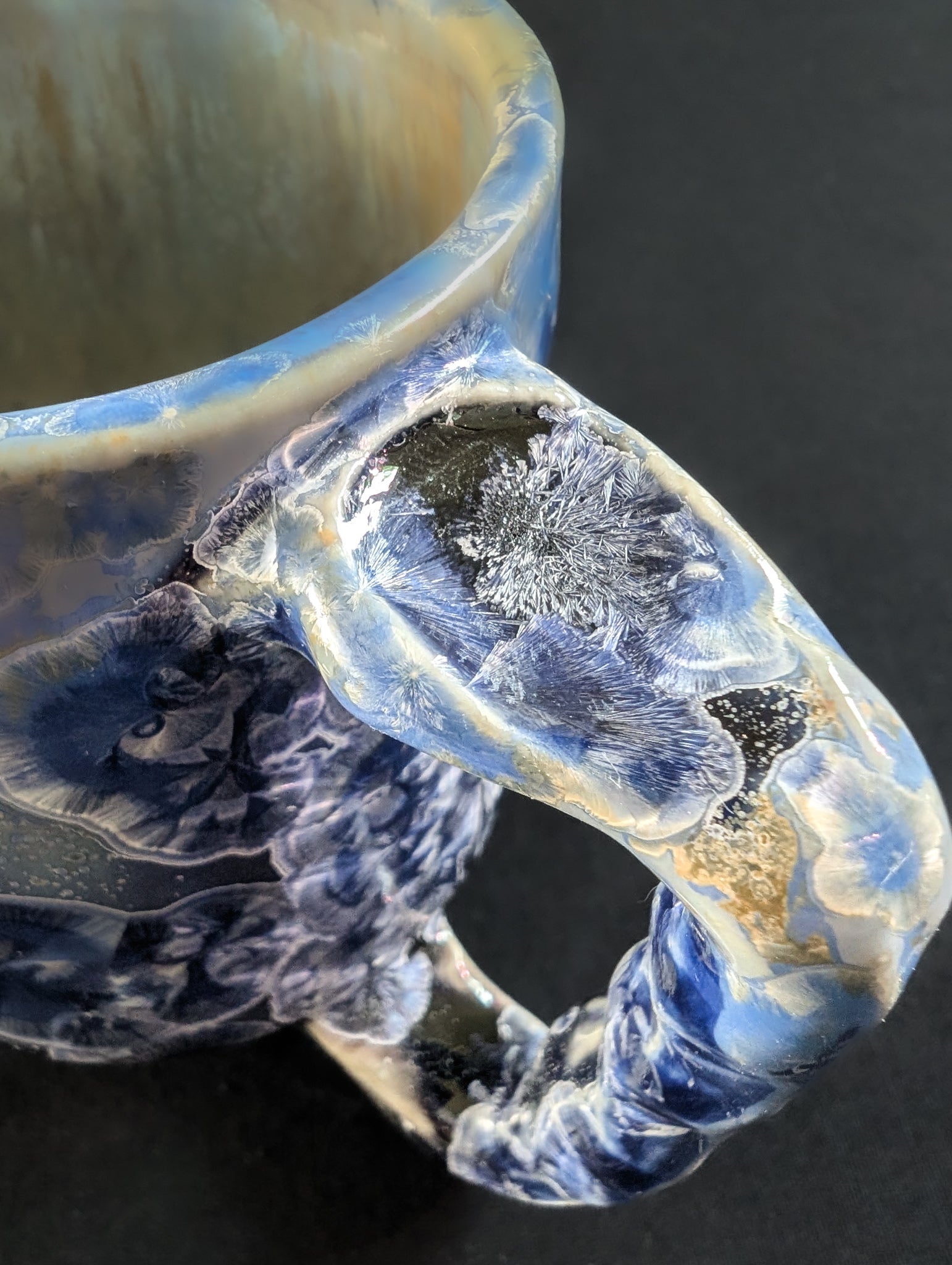 Close up of ergonomic handle on porcelain mug 'Dusk Reverie'.