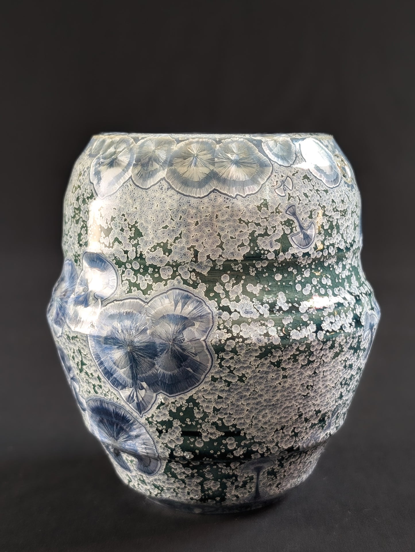 Porcelain crystalline vase by ceramic artist Robbin Harris against a black background.