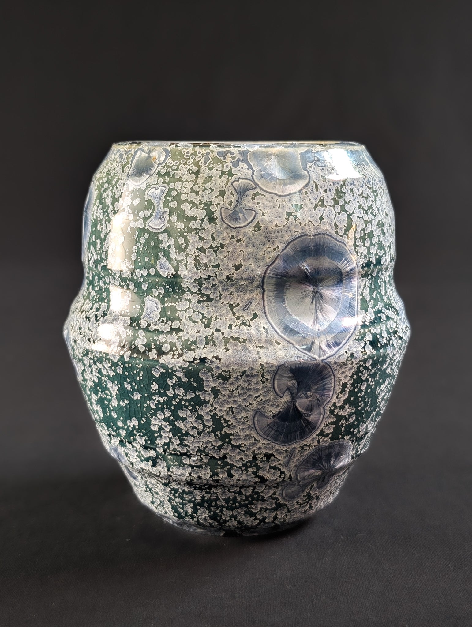 Decorative porcelain vase with crystallized surface on a dark background