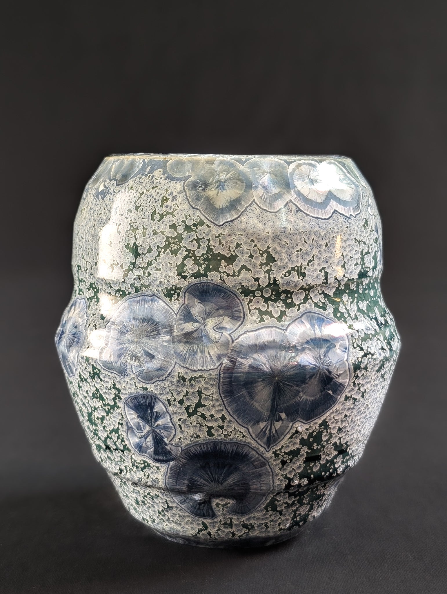 Frontal shot of 'Earth's Jewel' by ceramic artist Robbin Harris, featuring large sapphire crystals against an emerald green background.
