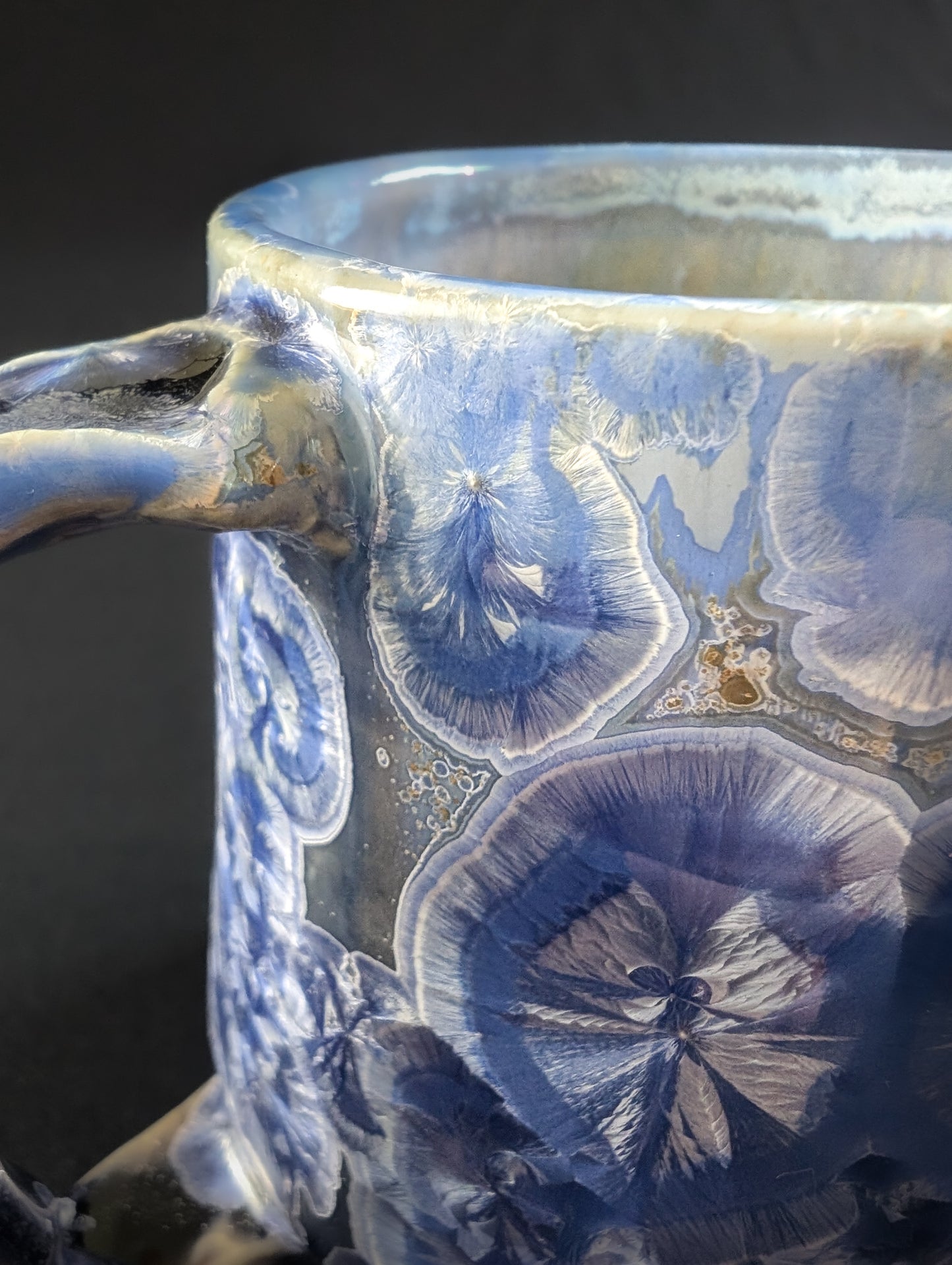 Ceramic mug with blue crystalline pattern on a dark background
