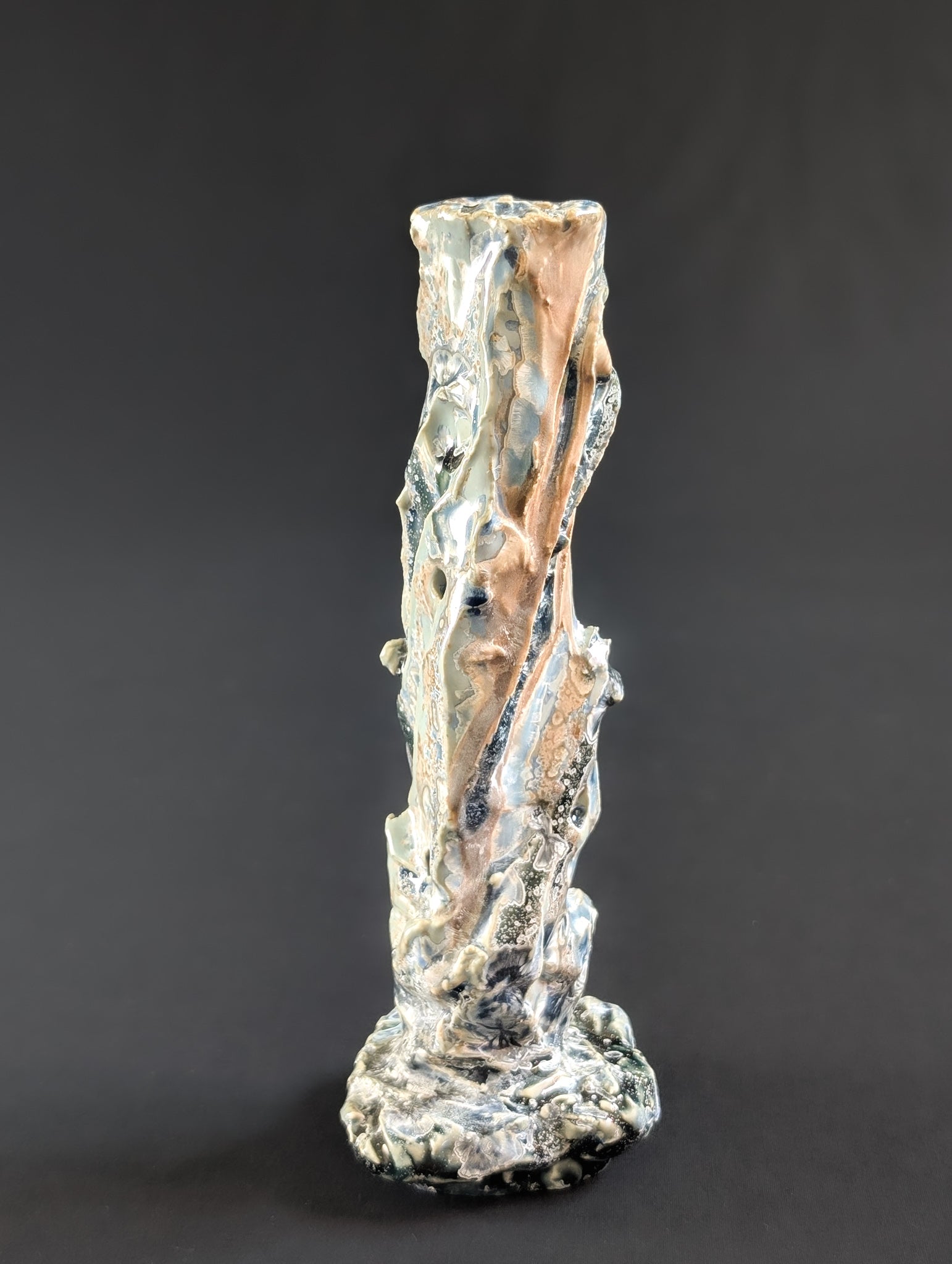 Rock bound, single flower vase by Robbin Harris against a dark background.