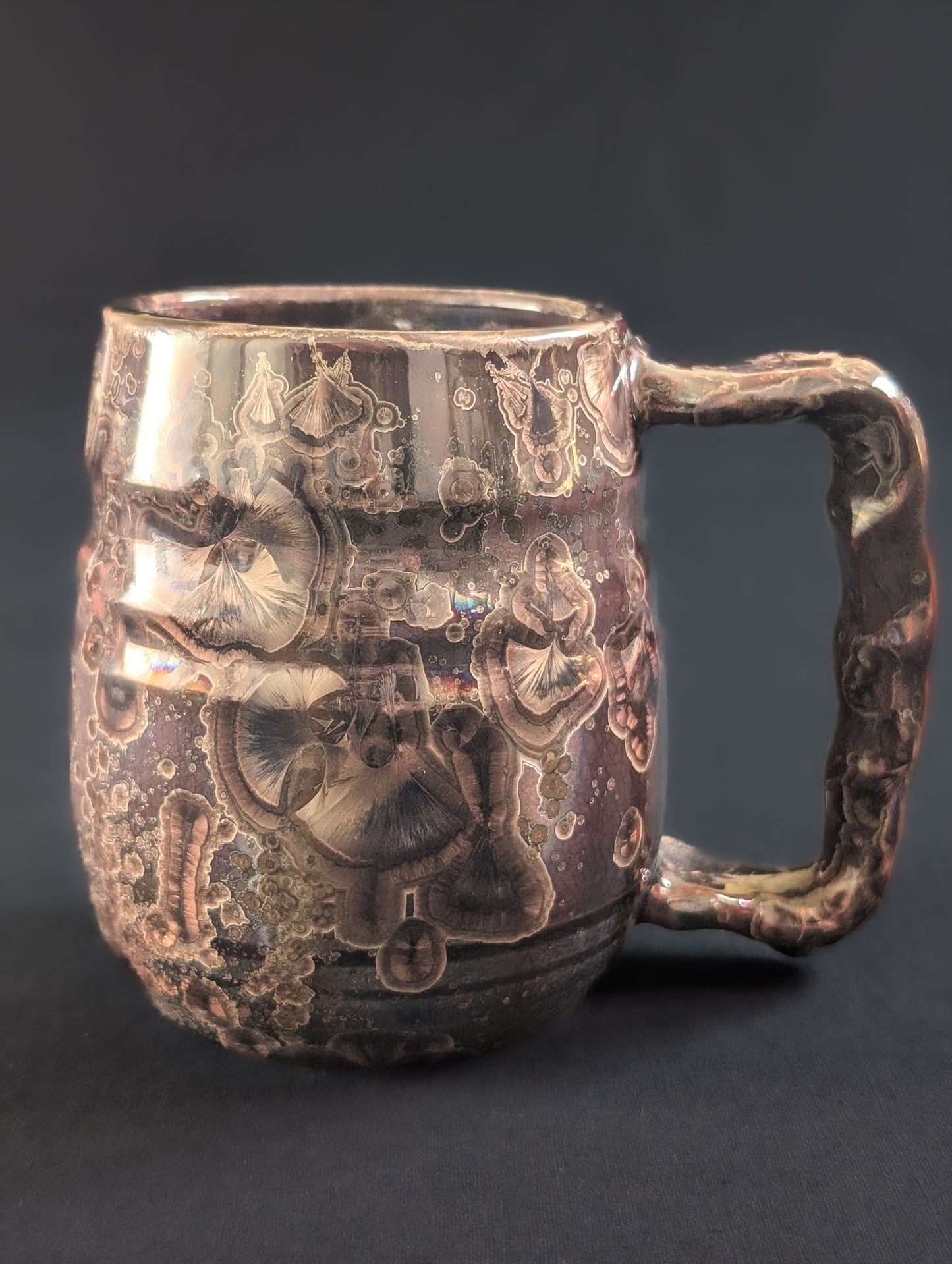 Decorative ceramic mug with intricate designs on a dark background