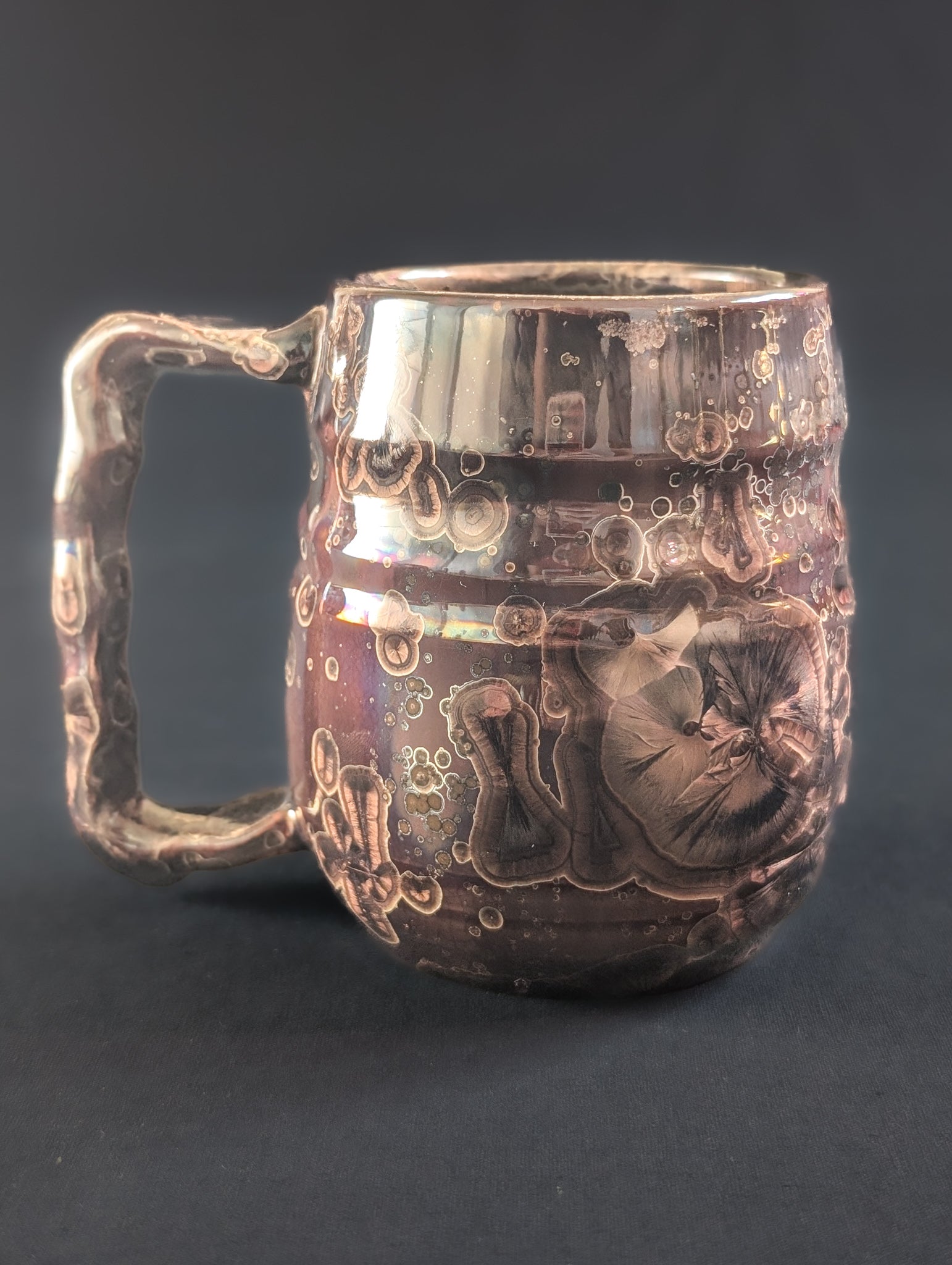 Porcelain, reduction fired mug, with brown crystals over the surface.