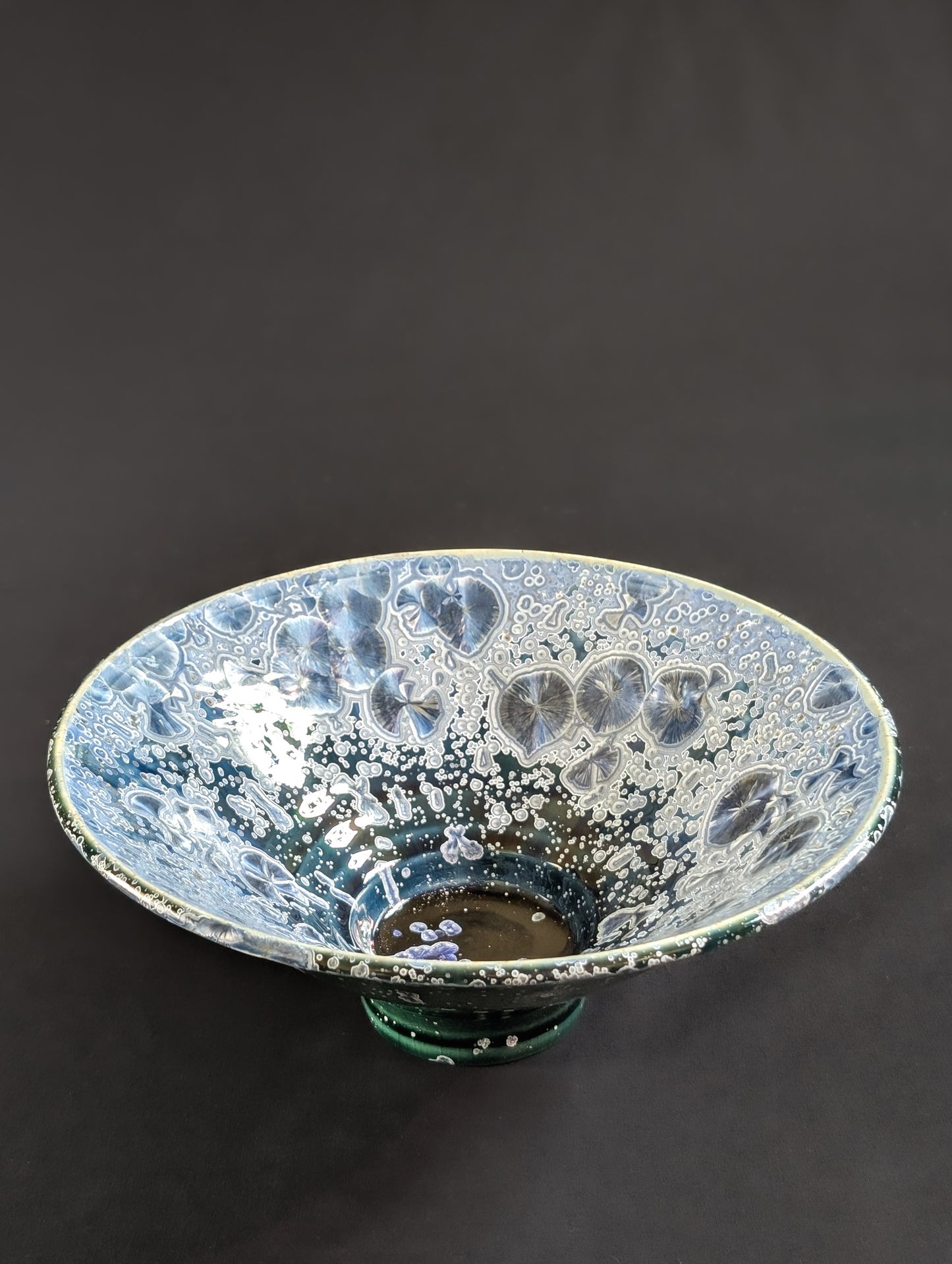 Ceramic bowl with crystalline surface on a dark background