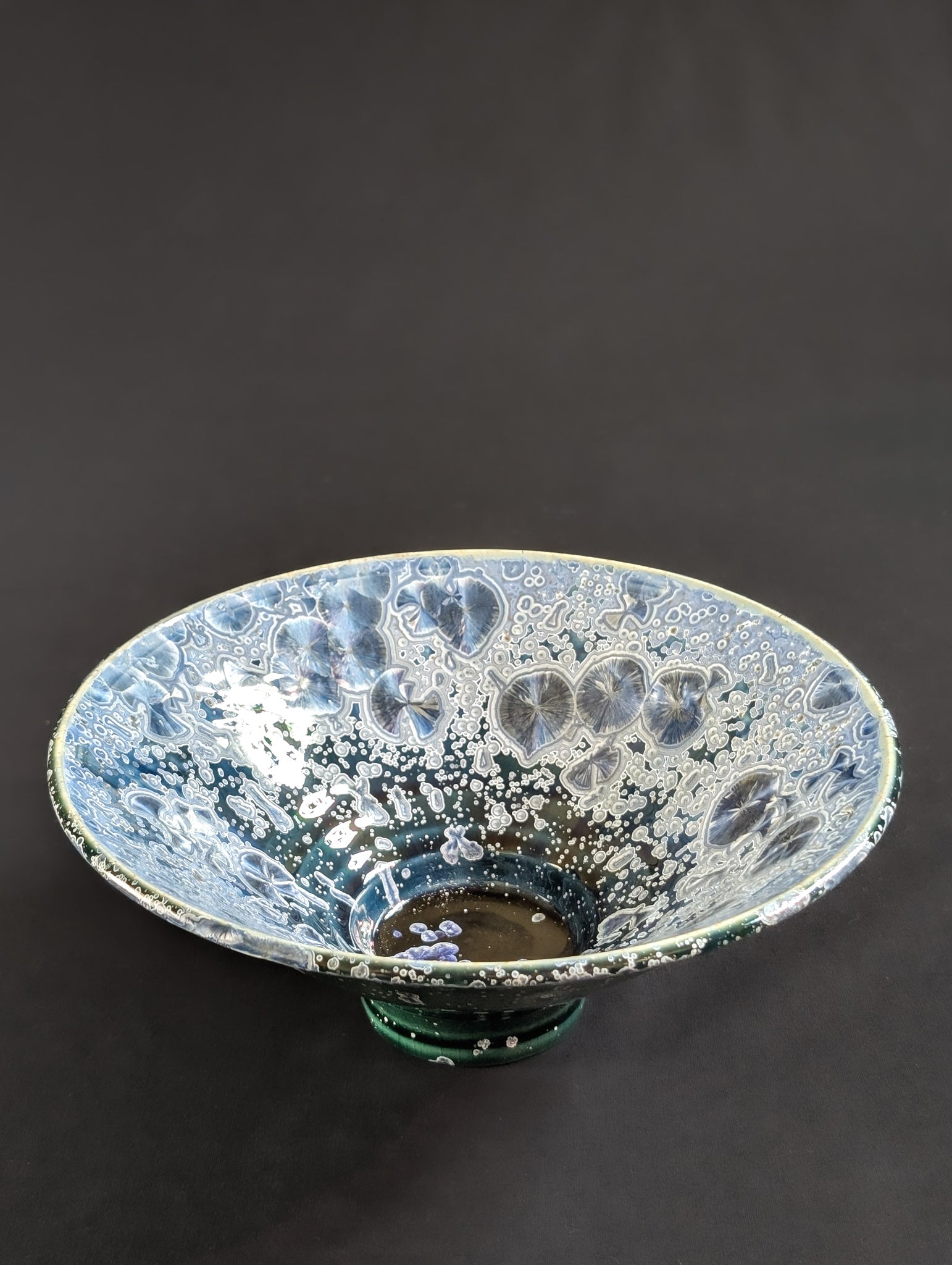 Ceramic bowl with crystalline surface on a dark background
