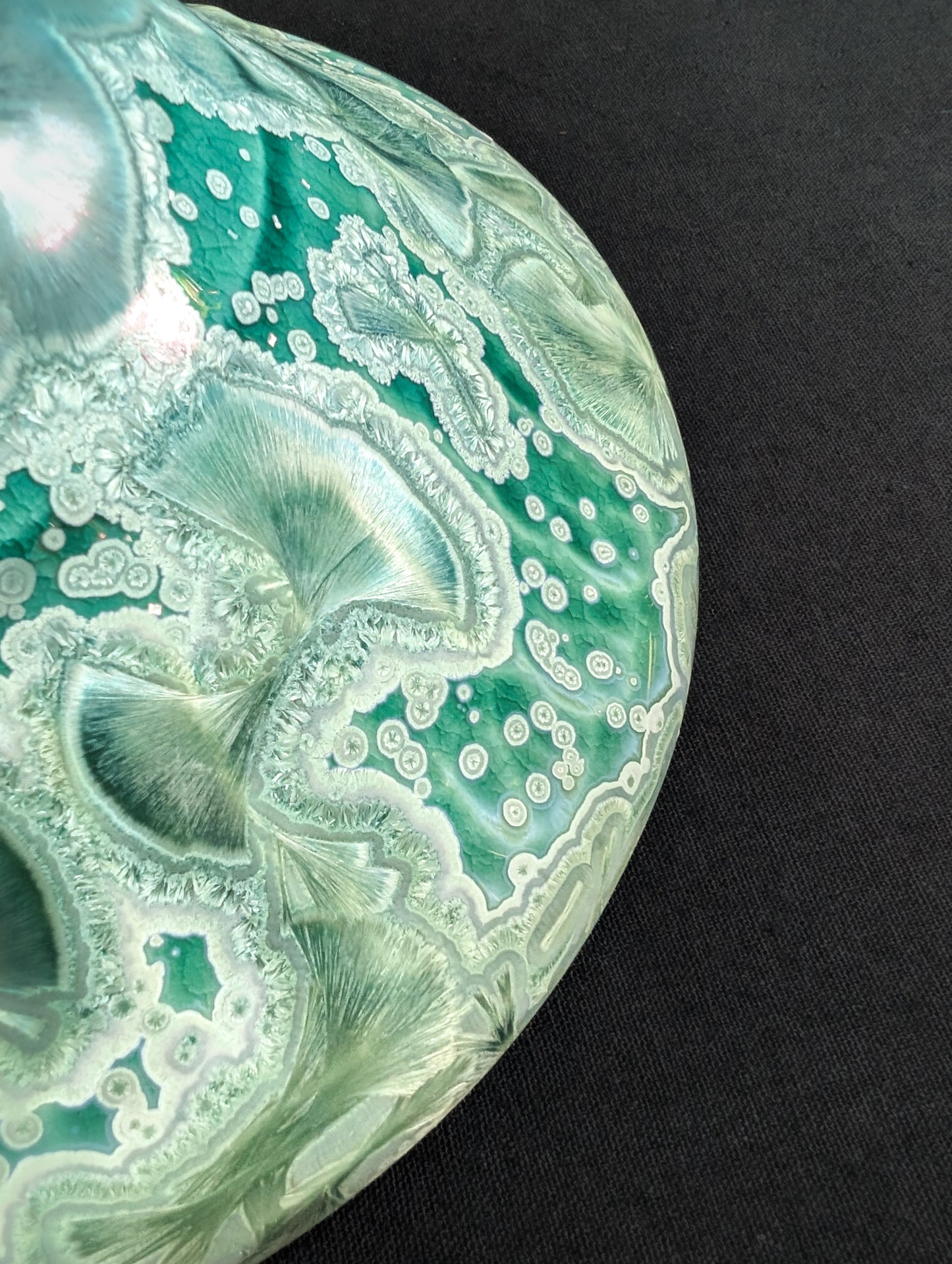 Close up of the outside rim of green porcelain ring dish.