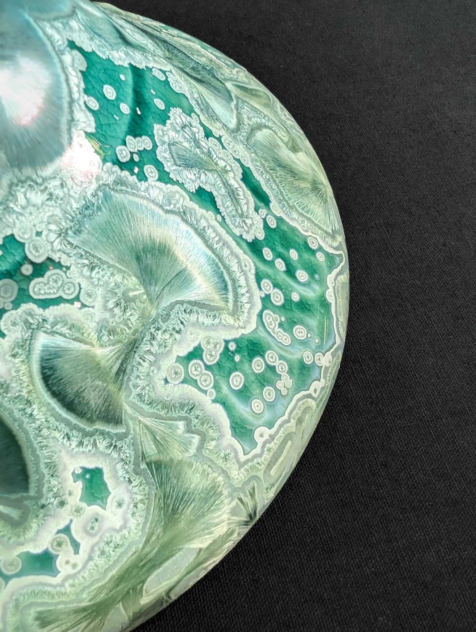 Close up of the outside rim of green porcelain ring dish.
