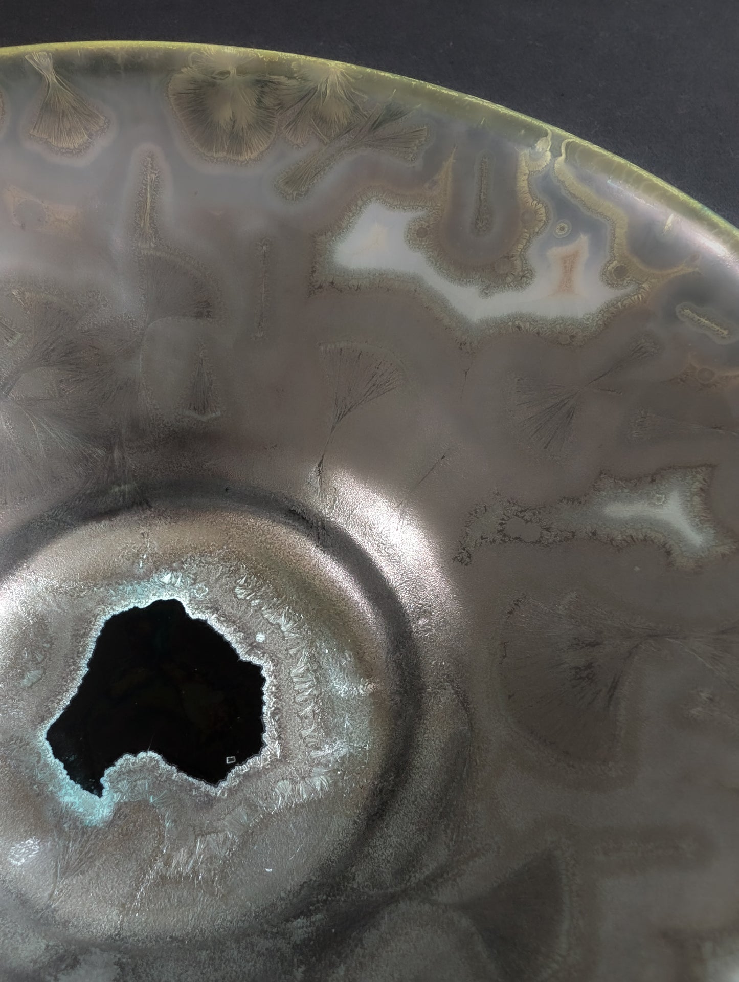 Close up of metal colored glaze on the inside of a crystalline ceramic trinket dish.