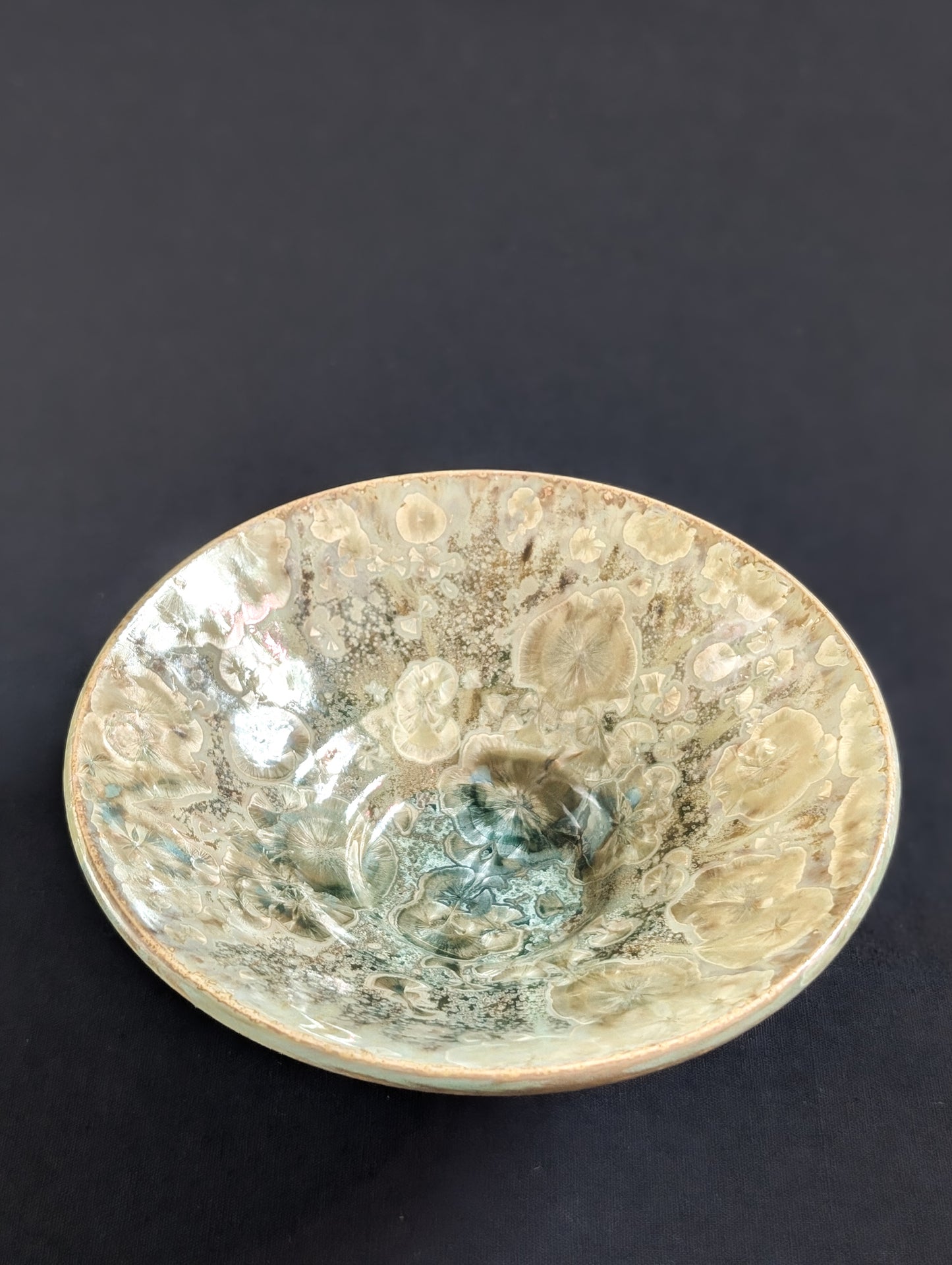 Top view of yellow and green crystalline dish by Robbin Harris against  black background.