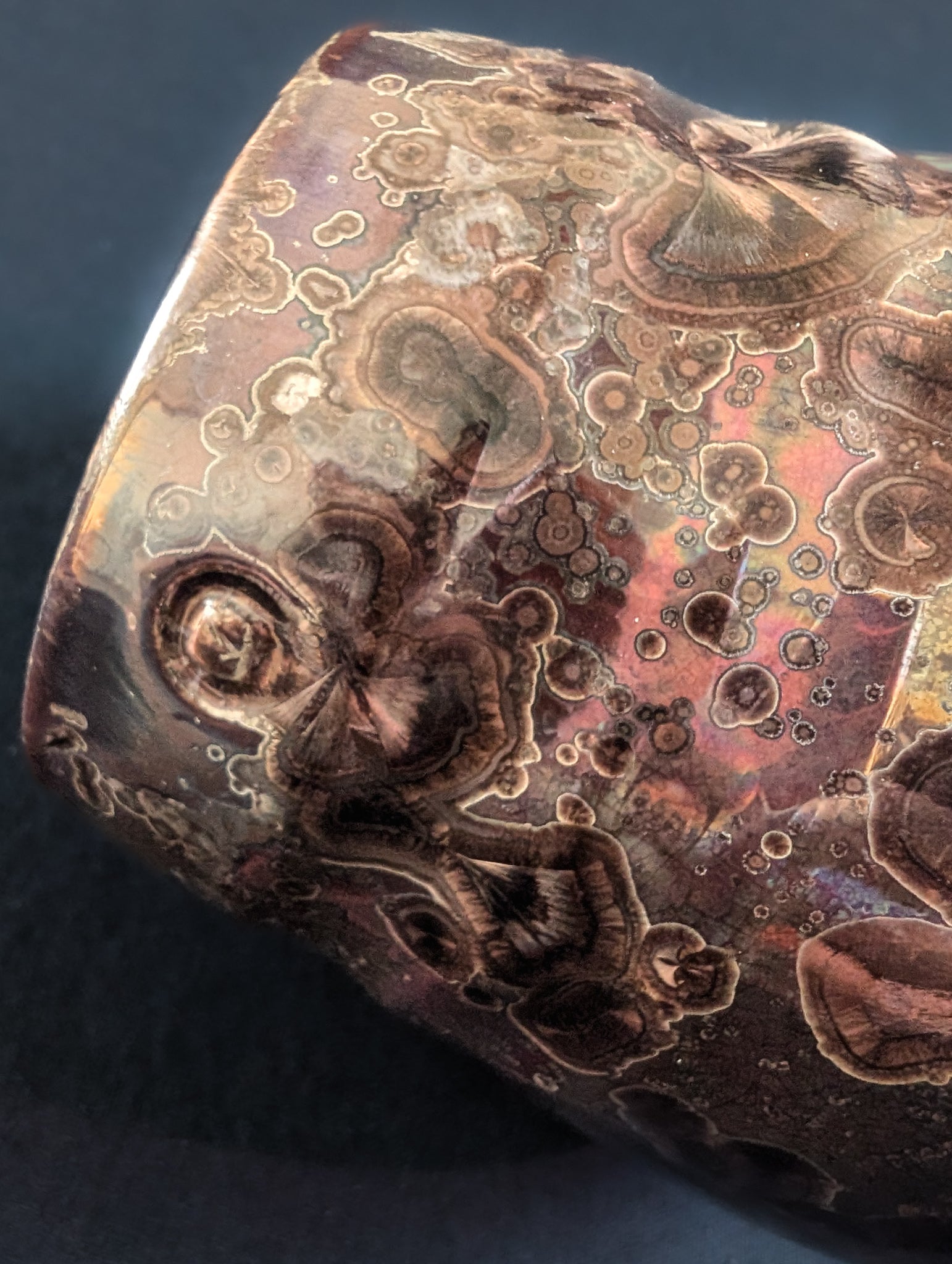 Molten-looking brown crystals blooming across a surface with hints of red and fire.