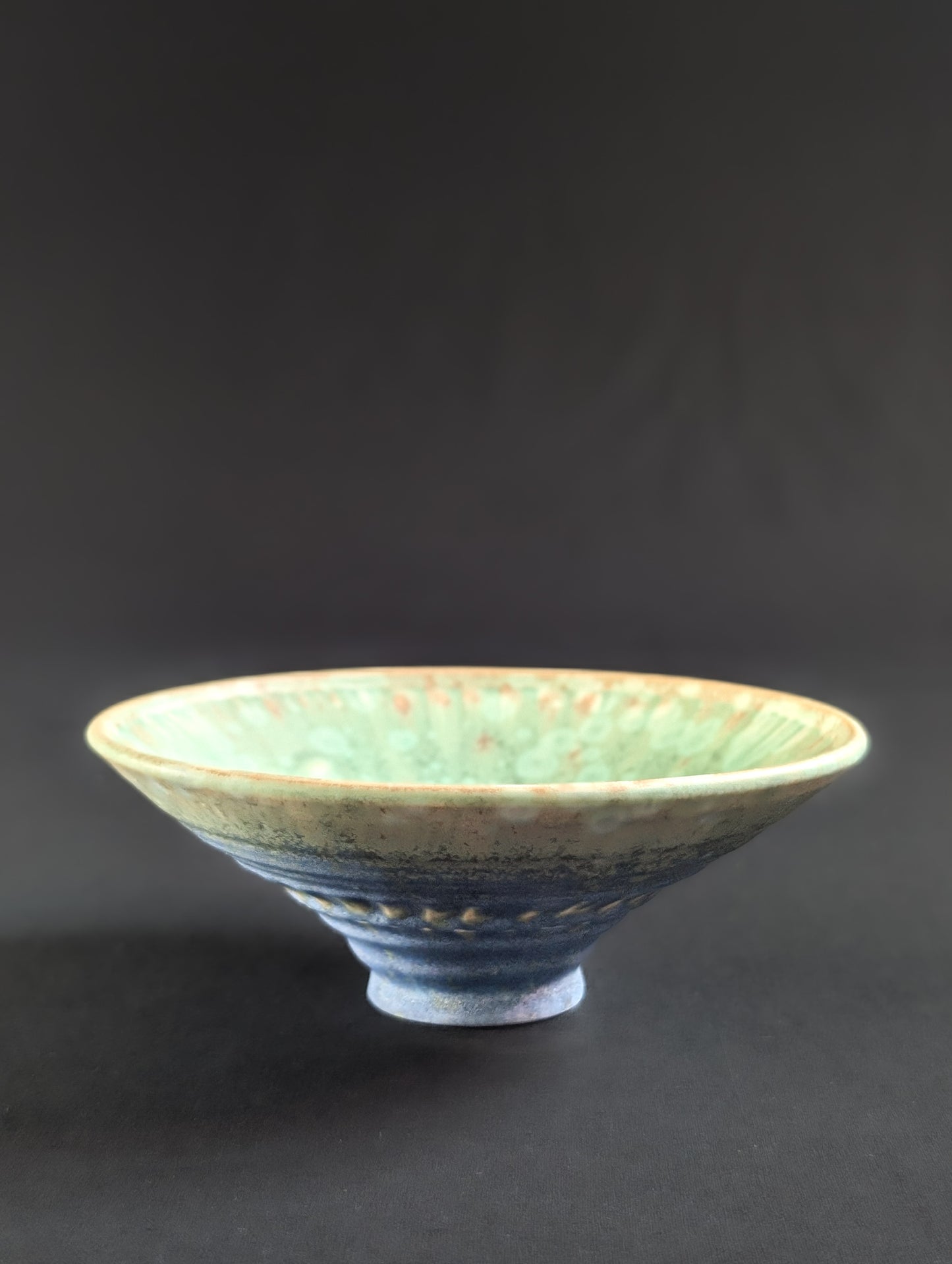 Ceramic bowl with textured surface on a dark background