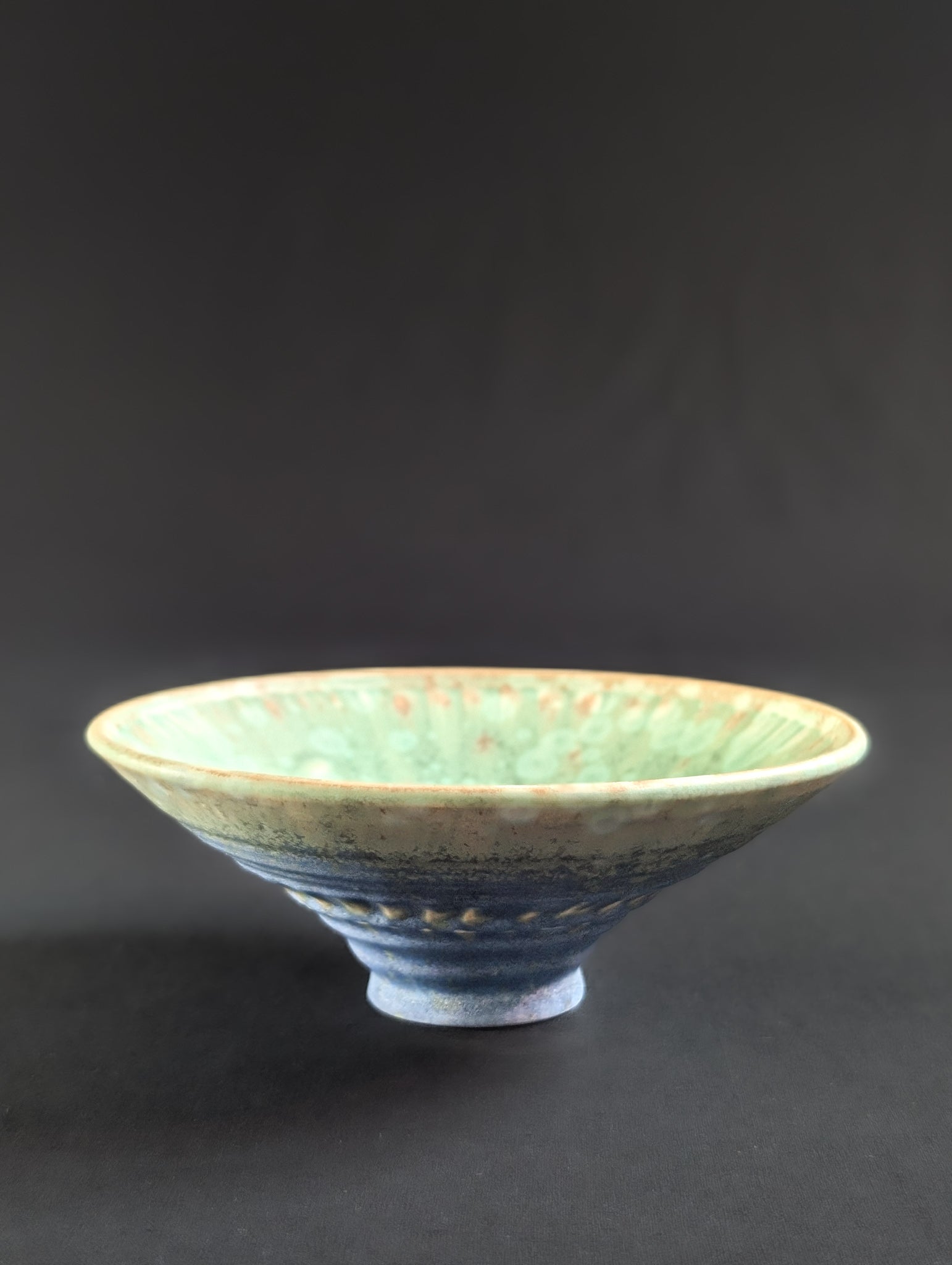 Ceramic bowl with textured surface on a dark background