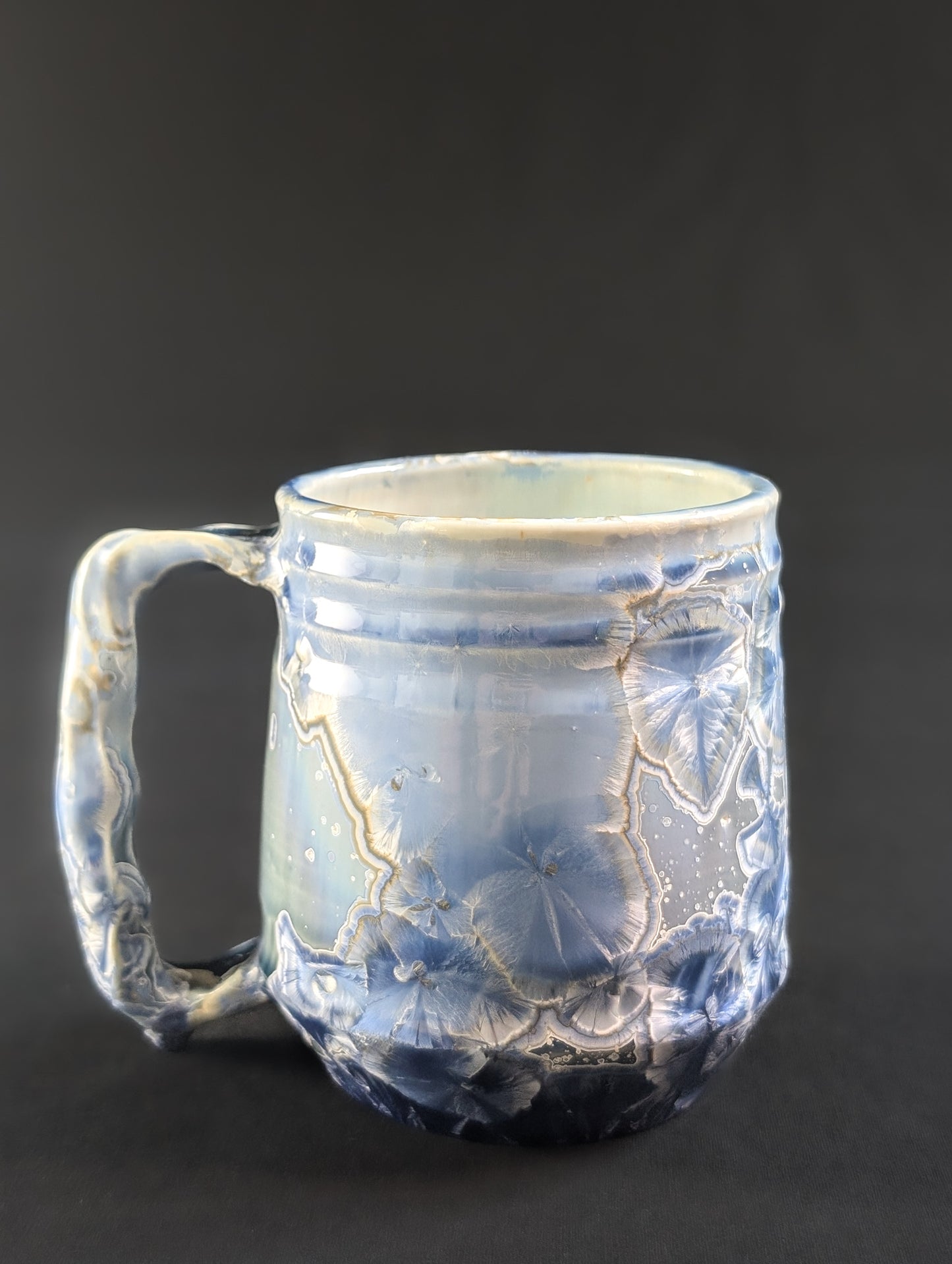 Opposite side of the Celestial Atlas mug, highlighting the organic glaze flow and detailed golden haloed crystals.