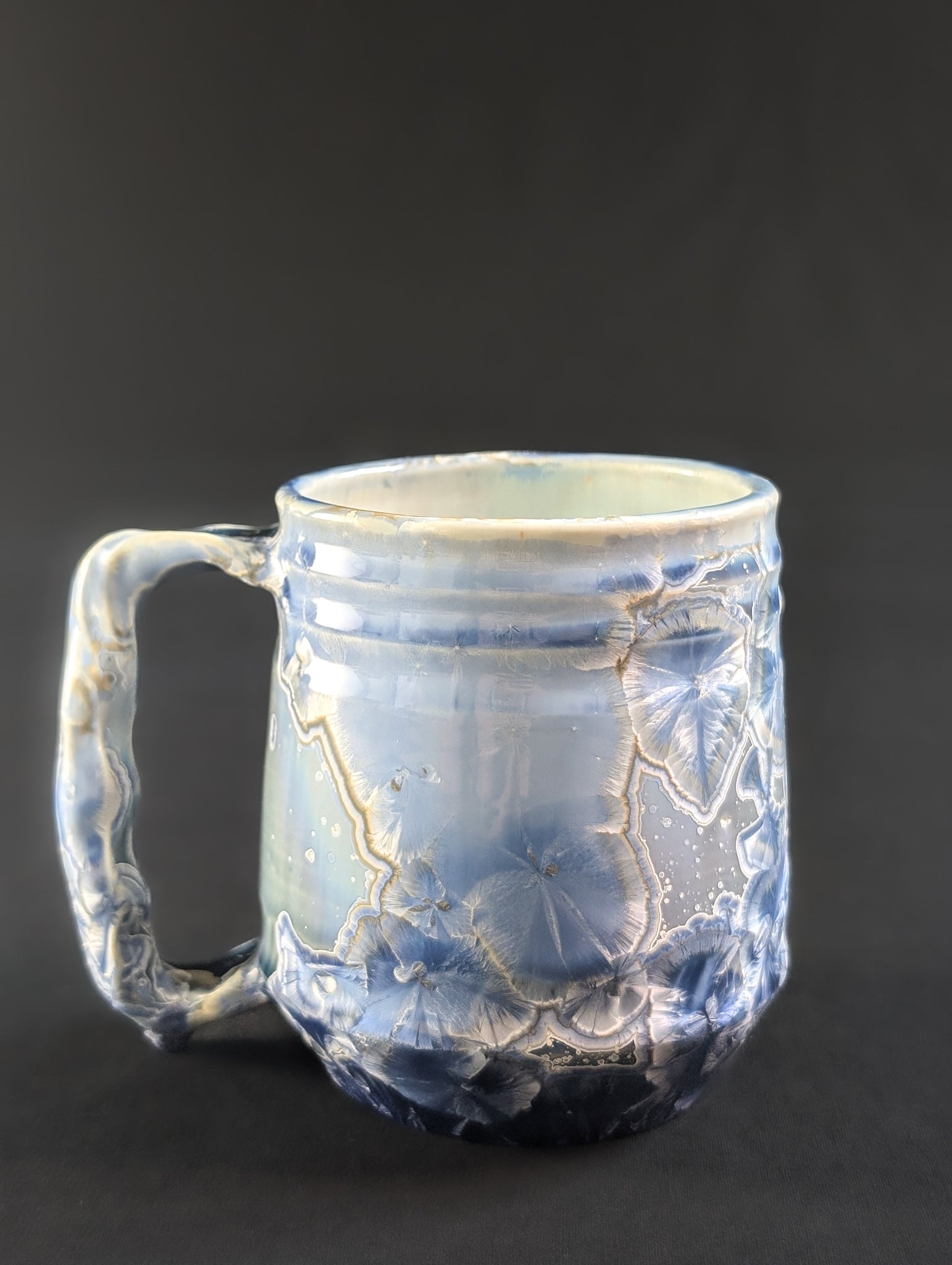 Opposite side of the Celestial Atlas mug, highlighting the organic glaze flow and detailed golden haloed crystals.