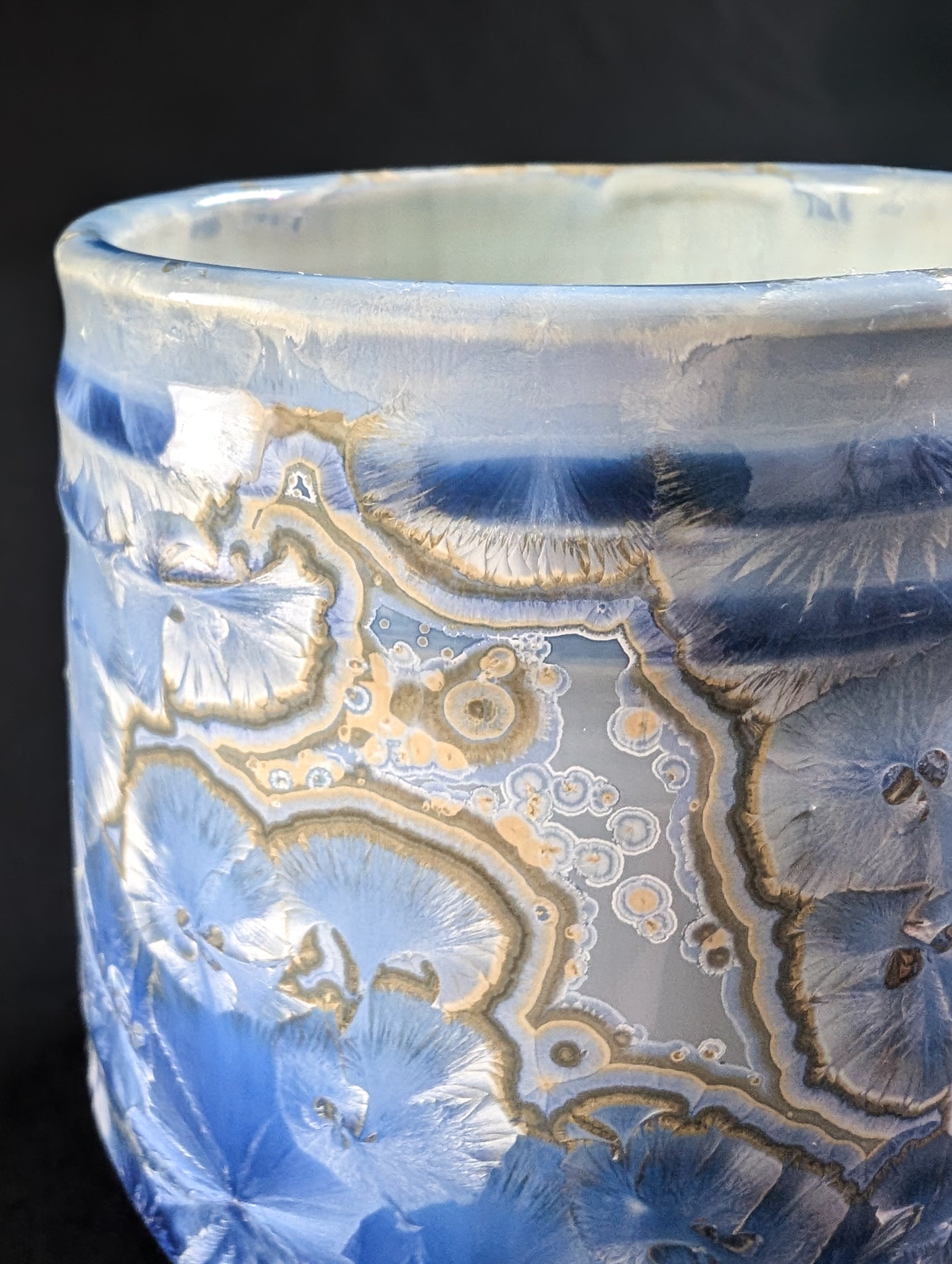 Detail of the crystalline glaze on Celestial Atlas, emphasizing large radial crystals with soft blue hues and gold edges.