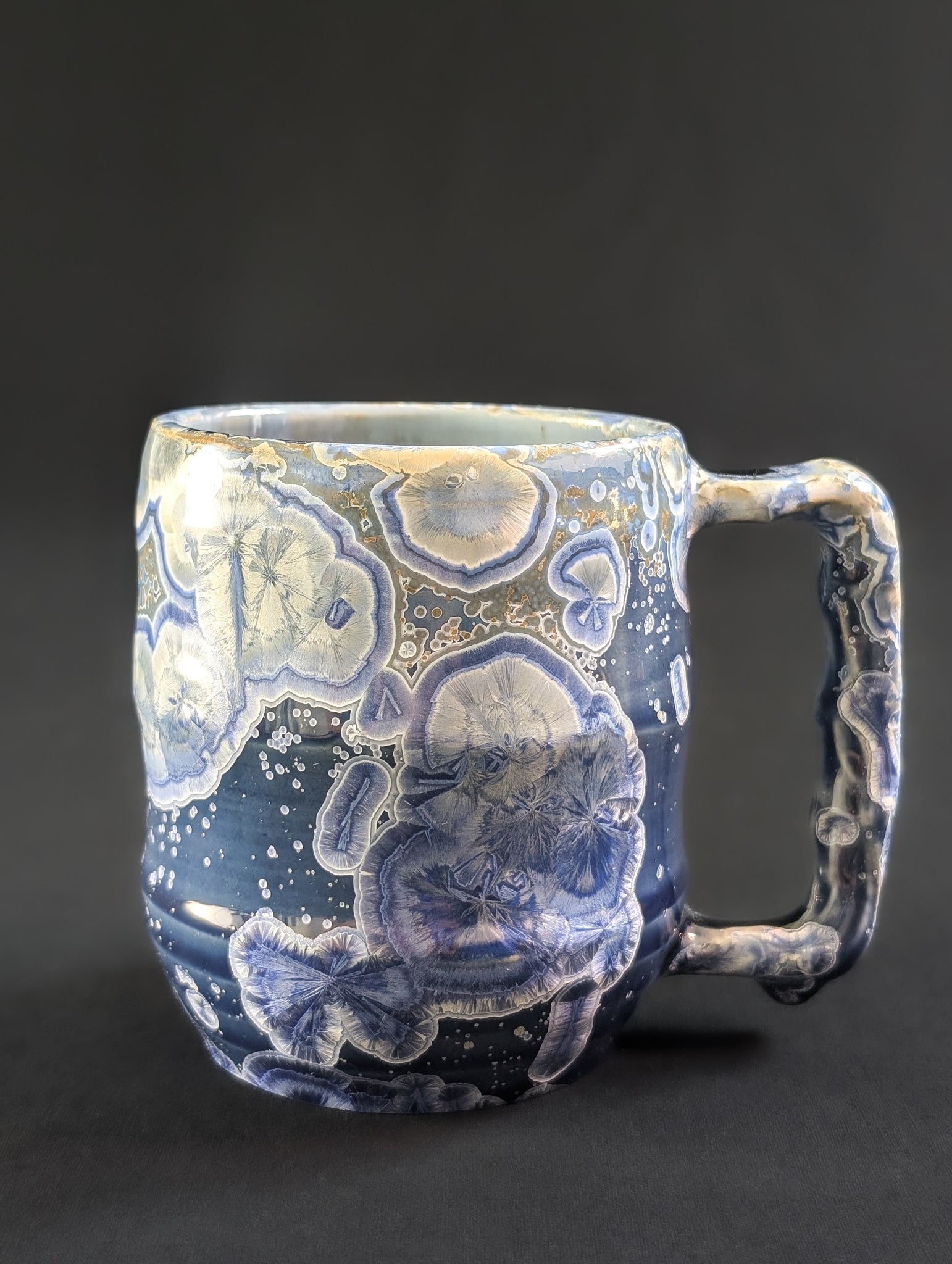 Mug 'Celestial Tides' as seen from the side with ergonomic handle.