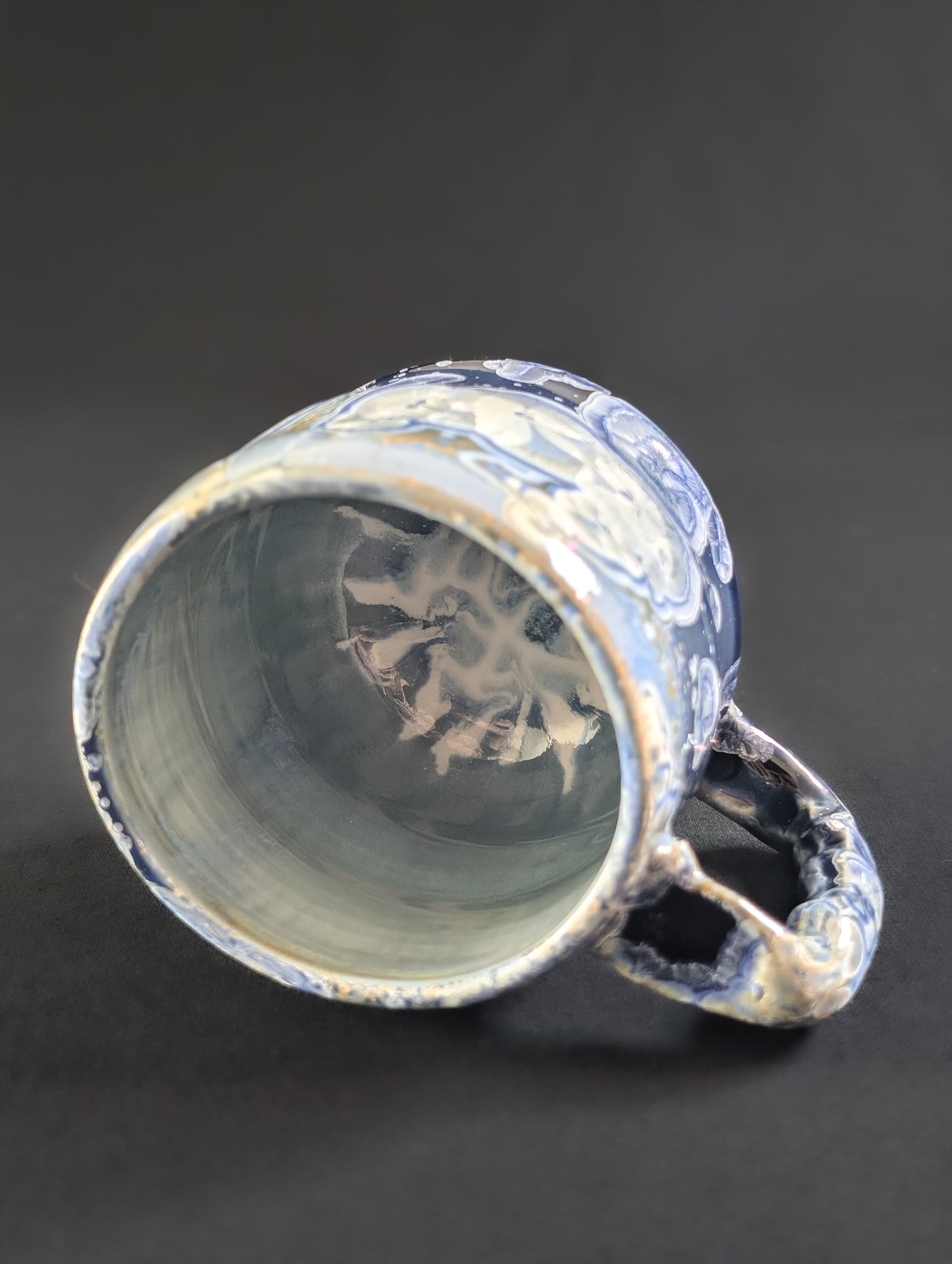 Ceramic mug with blue and white glaze on a dark background