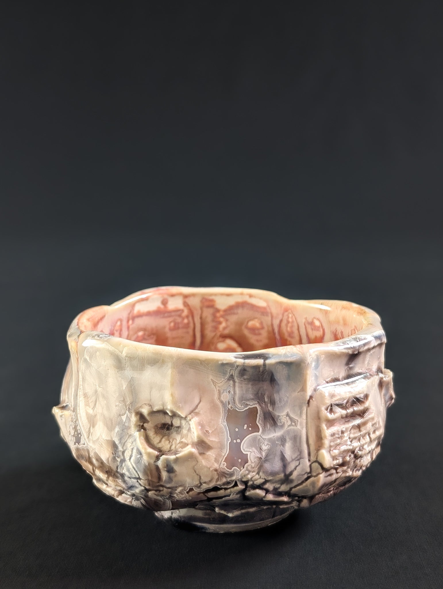 Porcelain tea bowl with textured surface on a black background