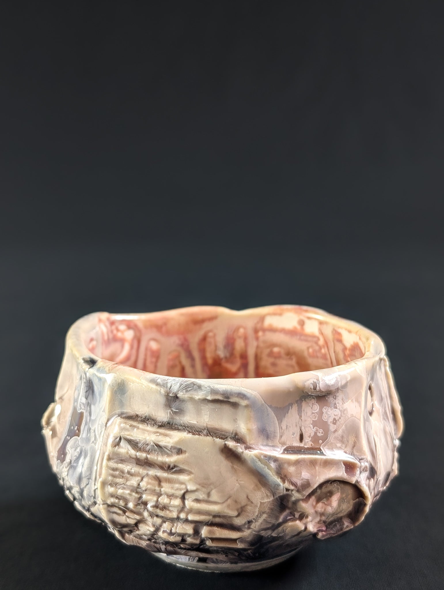 Decorative ceramic tea bowl with intricate designs on a black background