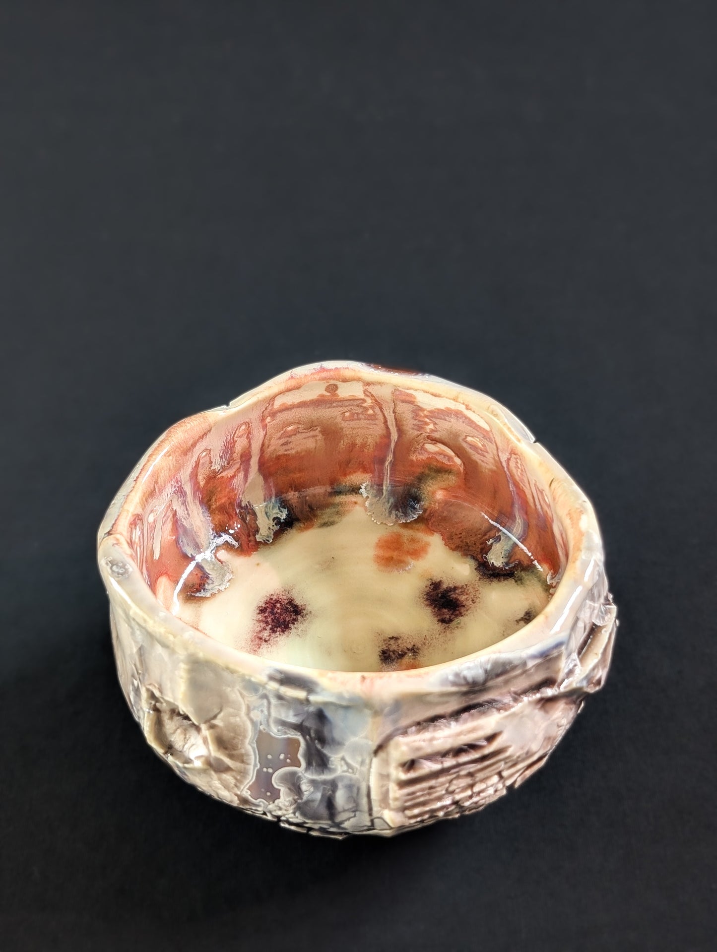 Interior of the tea bowl, showing a smooth, glowing glaze in deeper pinks with natural flow and movement.