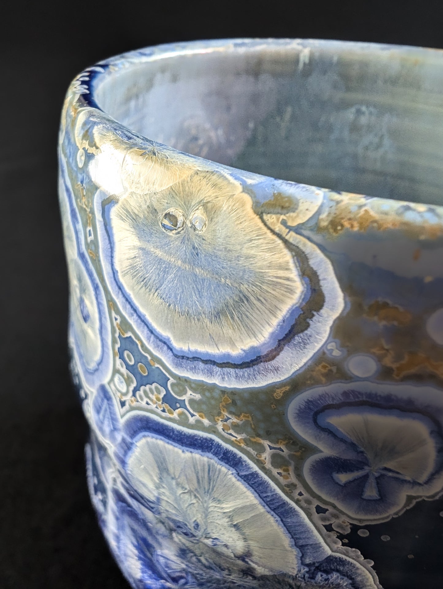 Close-up of a ceramic bowl with agate-like patterns on a dark background