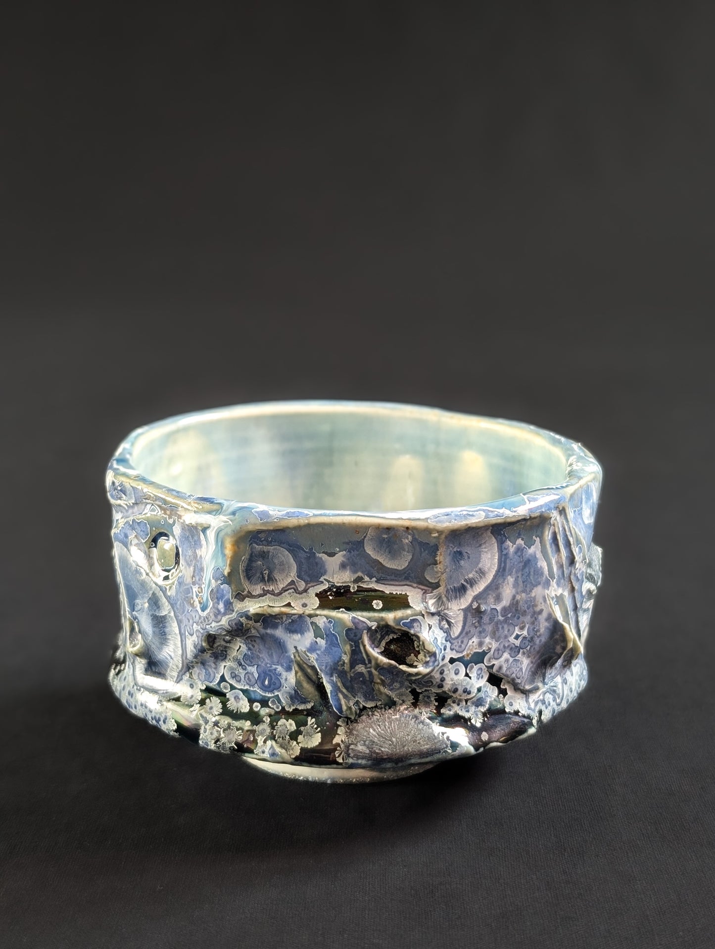 Angled side view of 'Nightsky' chawan, highlighting the textured surface and scattered crystalline patterns.