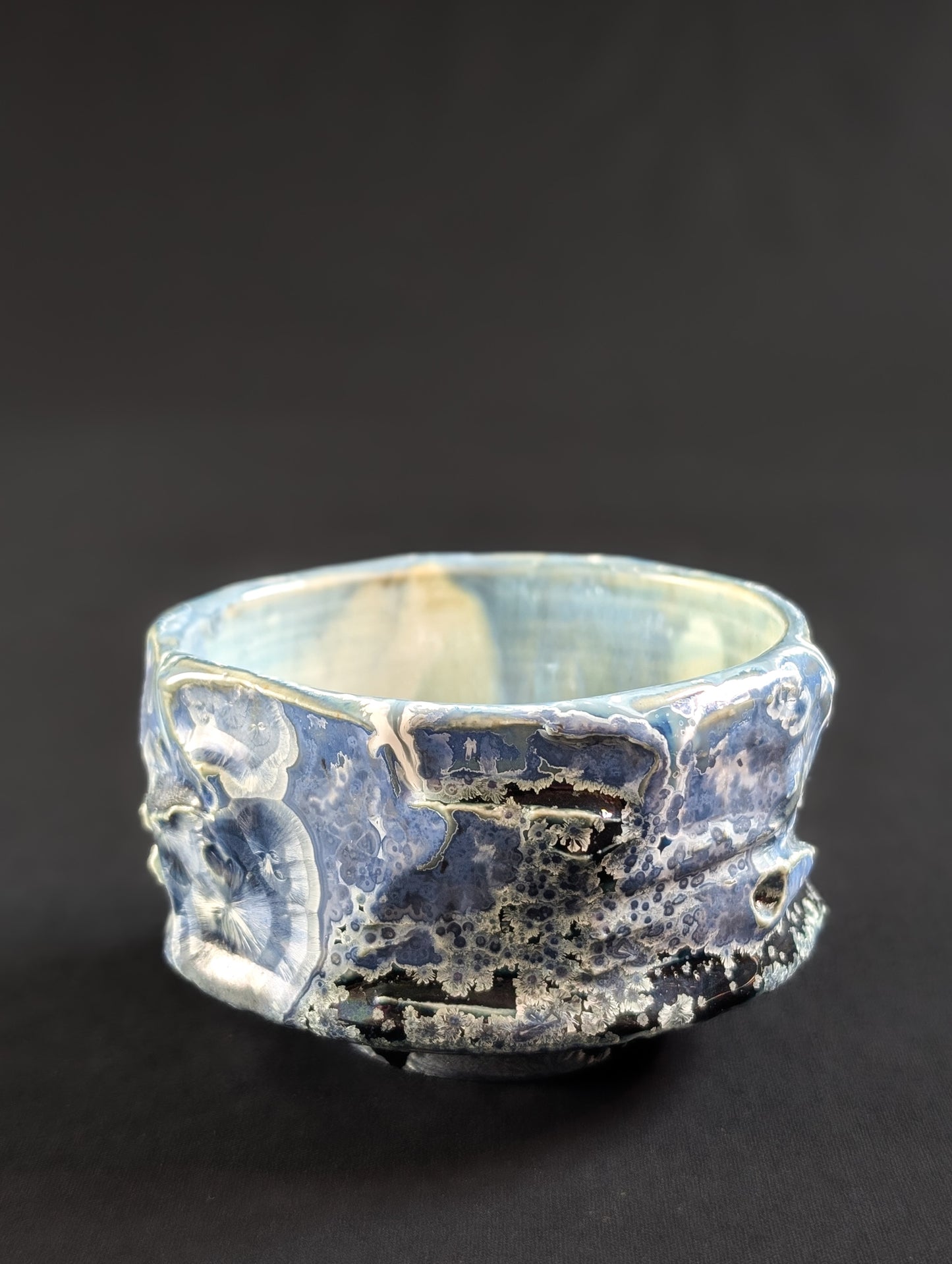 Chawan 'nightskye' side view with light blue crystals surrounded by white halo's against a deep blue background glaze.