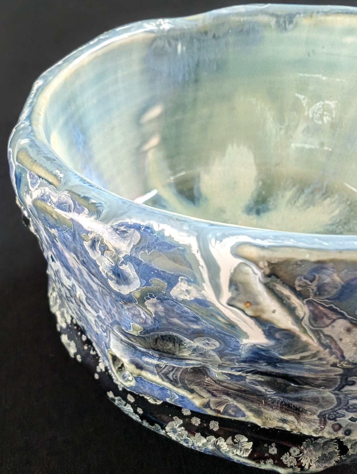 Close-up of the chawan glaze, showing tiny blue-and-white crystals emerging from a richly textured, dark blue base.