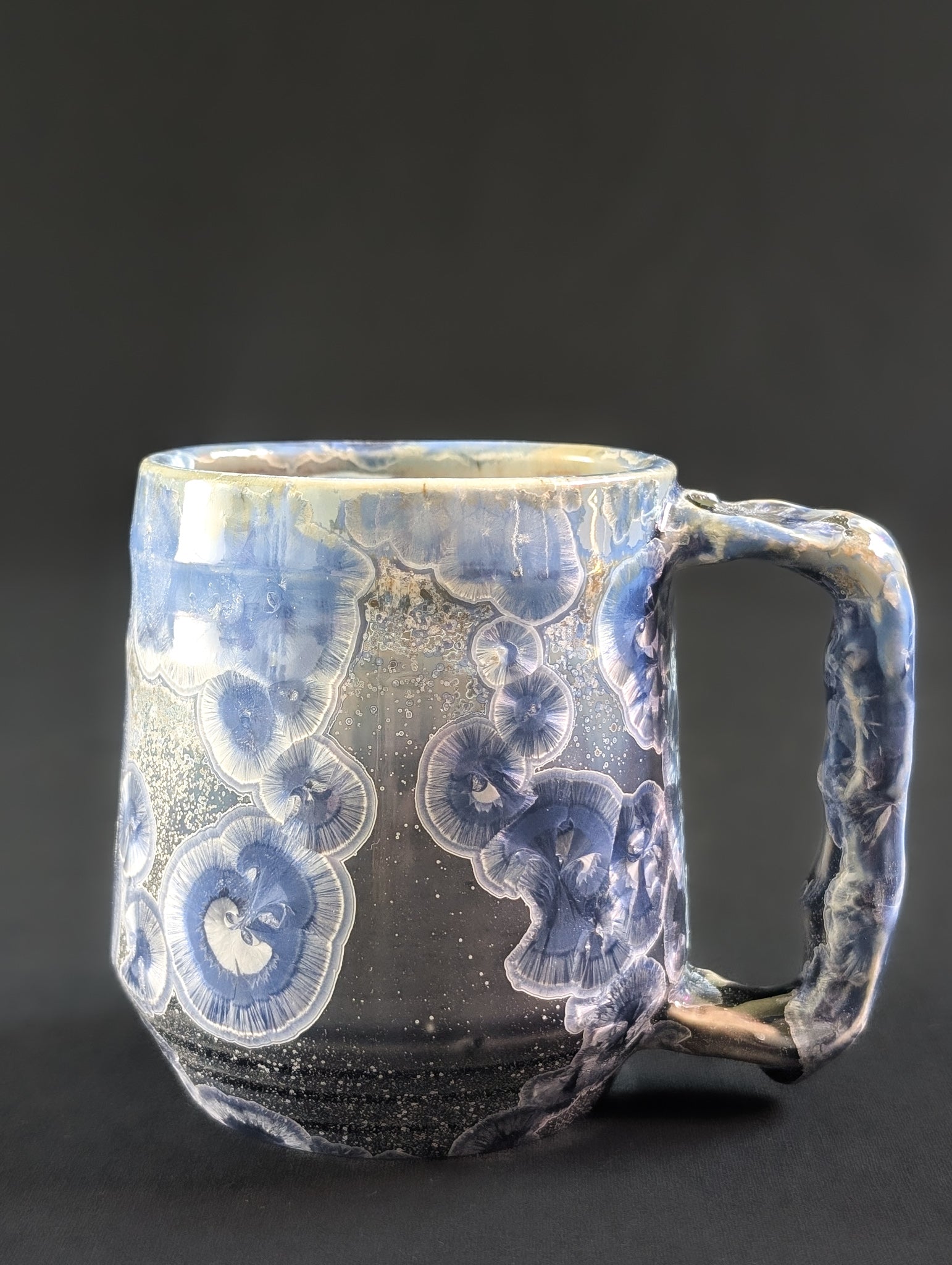 Porcelain mug with blue and white crystals on a black background