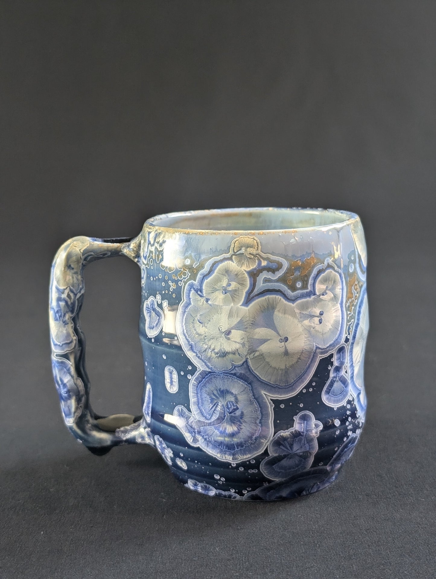 Celestial Tides mug in rich blue porcelain with white and gold-rimmed crystals.
