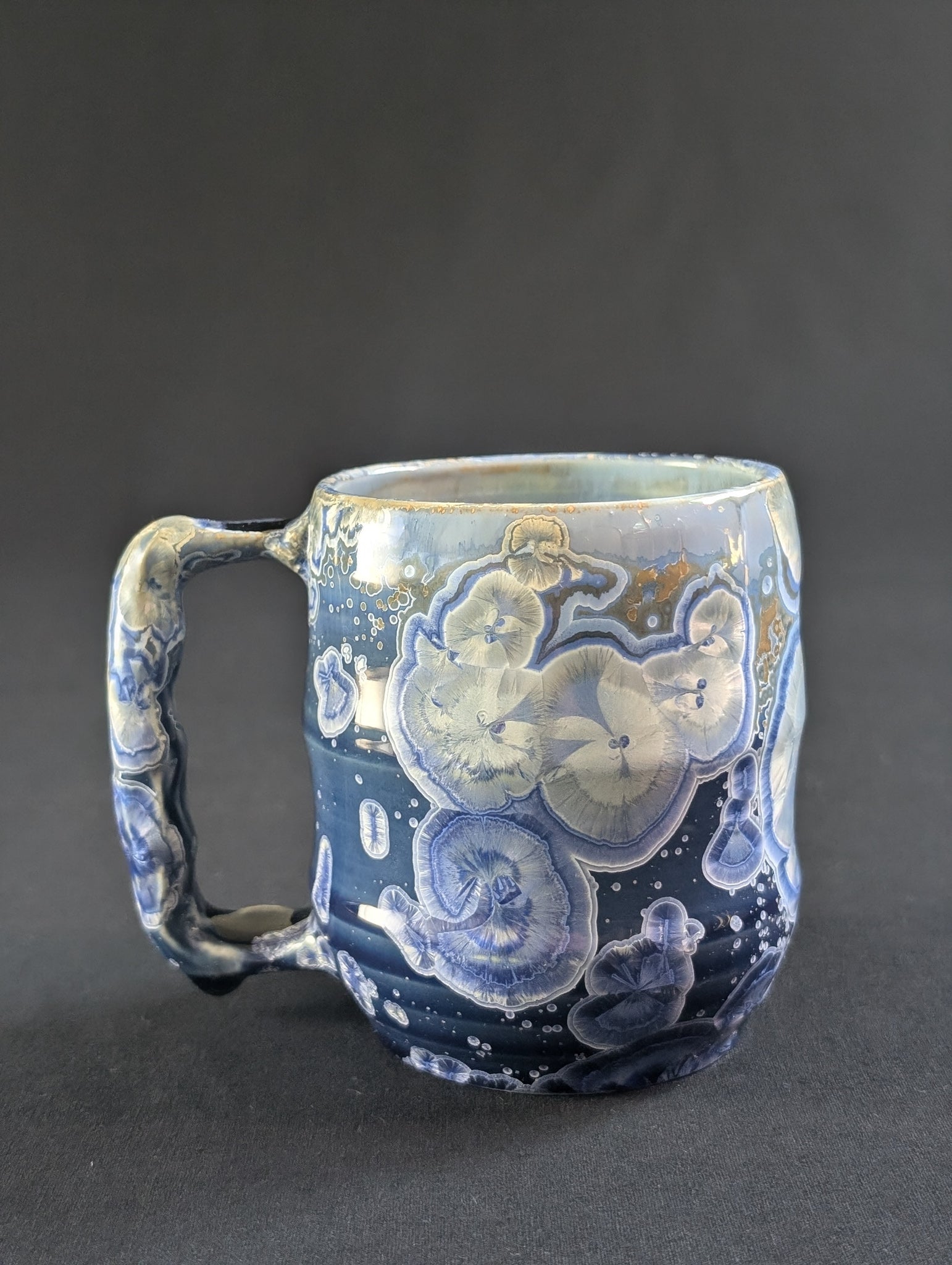 Celestial Tides mug in rich blue porcelain with white and gold-rimmed crystals.
