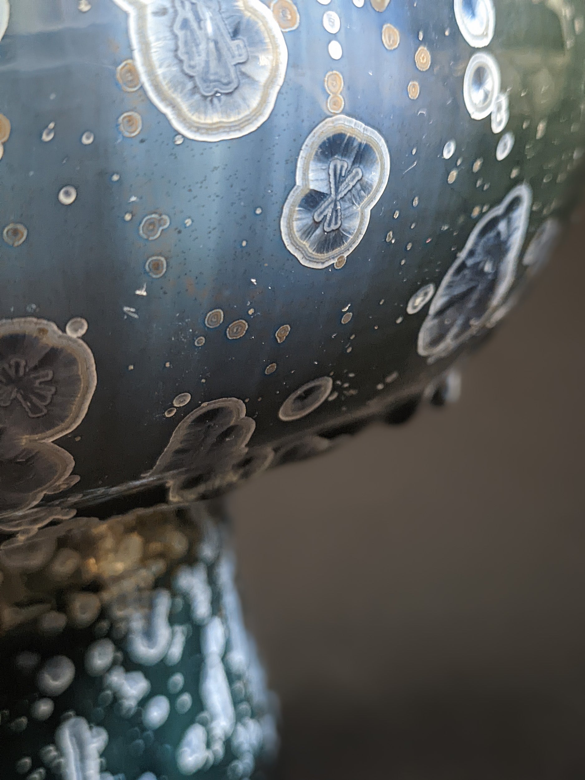 Focused view of the glaze’s flowing patterns and rich, verdant hues.