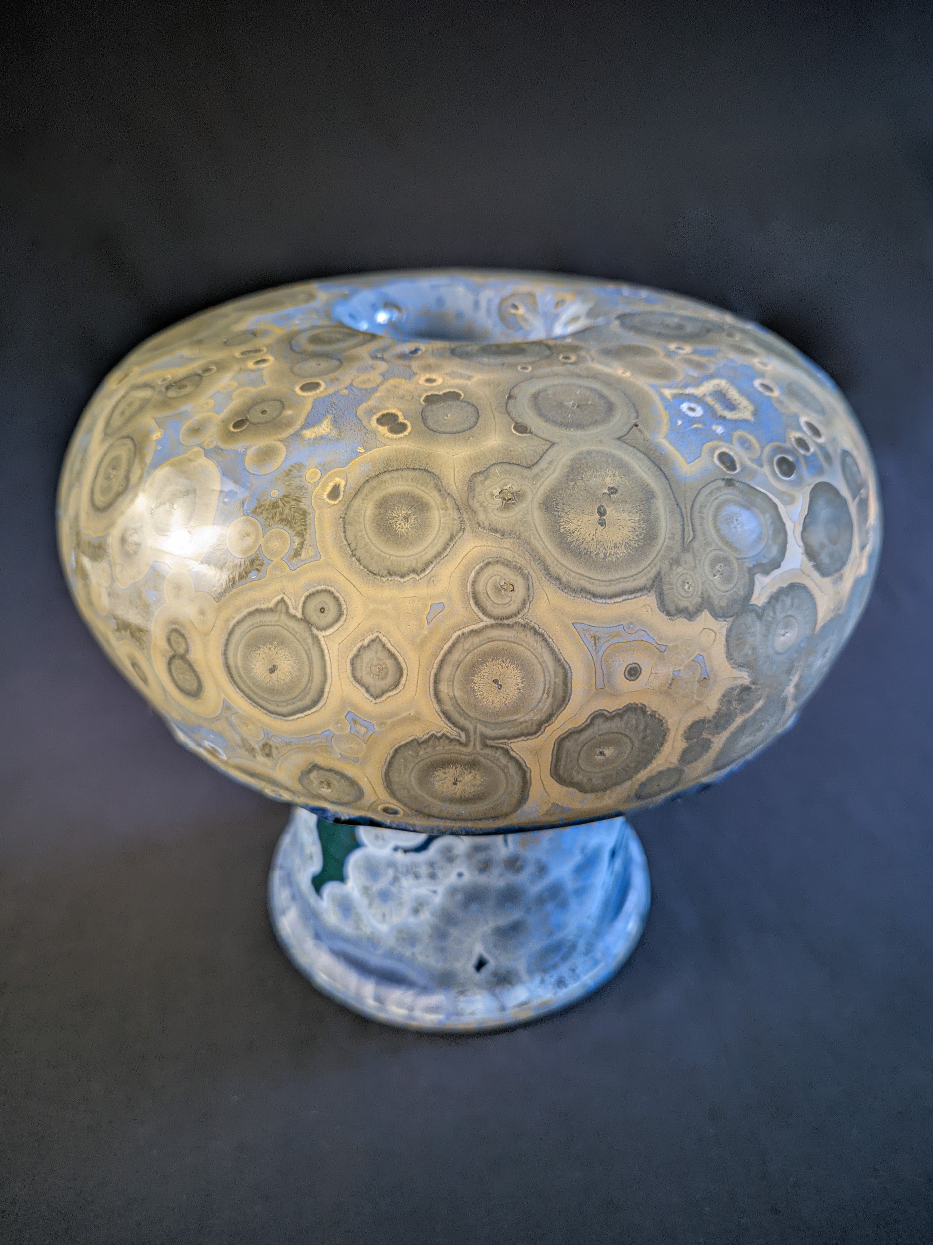 Chunky mushroom vase titled "Psychedelic Bloom" with a blue base featuring blue crystals and a bulbous yellow cap with beige crystals, showcasing intricate porcelain craftsmanship.