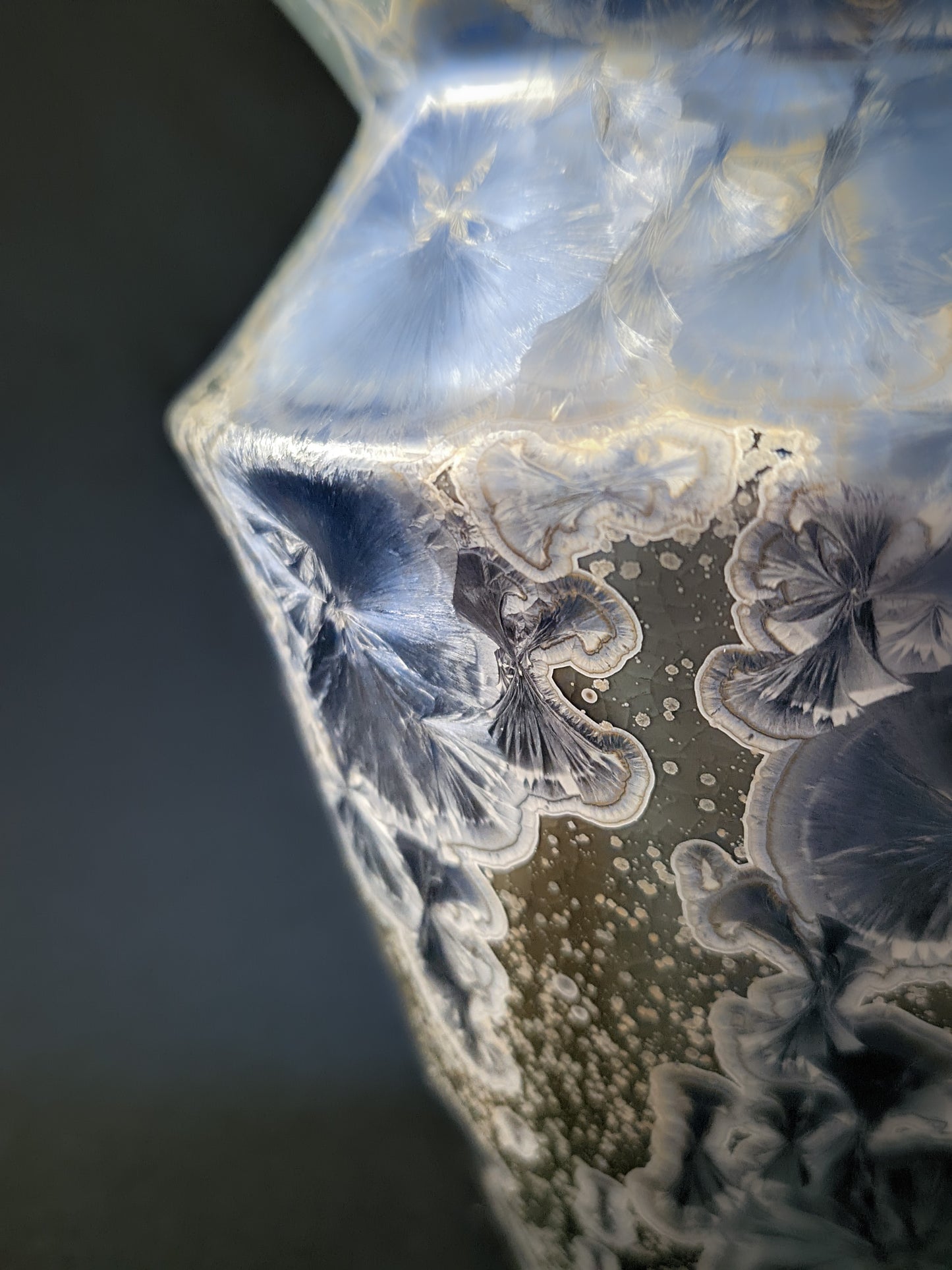 Close-up of the Frozen Serenity vase, focusing on its angled sides and prominent crystalline formations, with large blue and silver crystals contrasted against the smooth glaze.