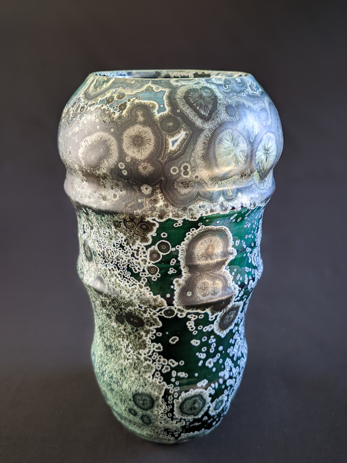 Handmade emerald green crystalline-glazed vase with intricate nickel and gold crystals, rounded top, and sculpted silhouette.