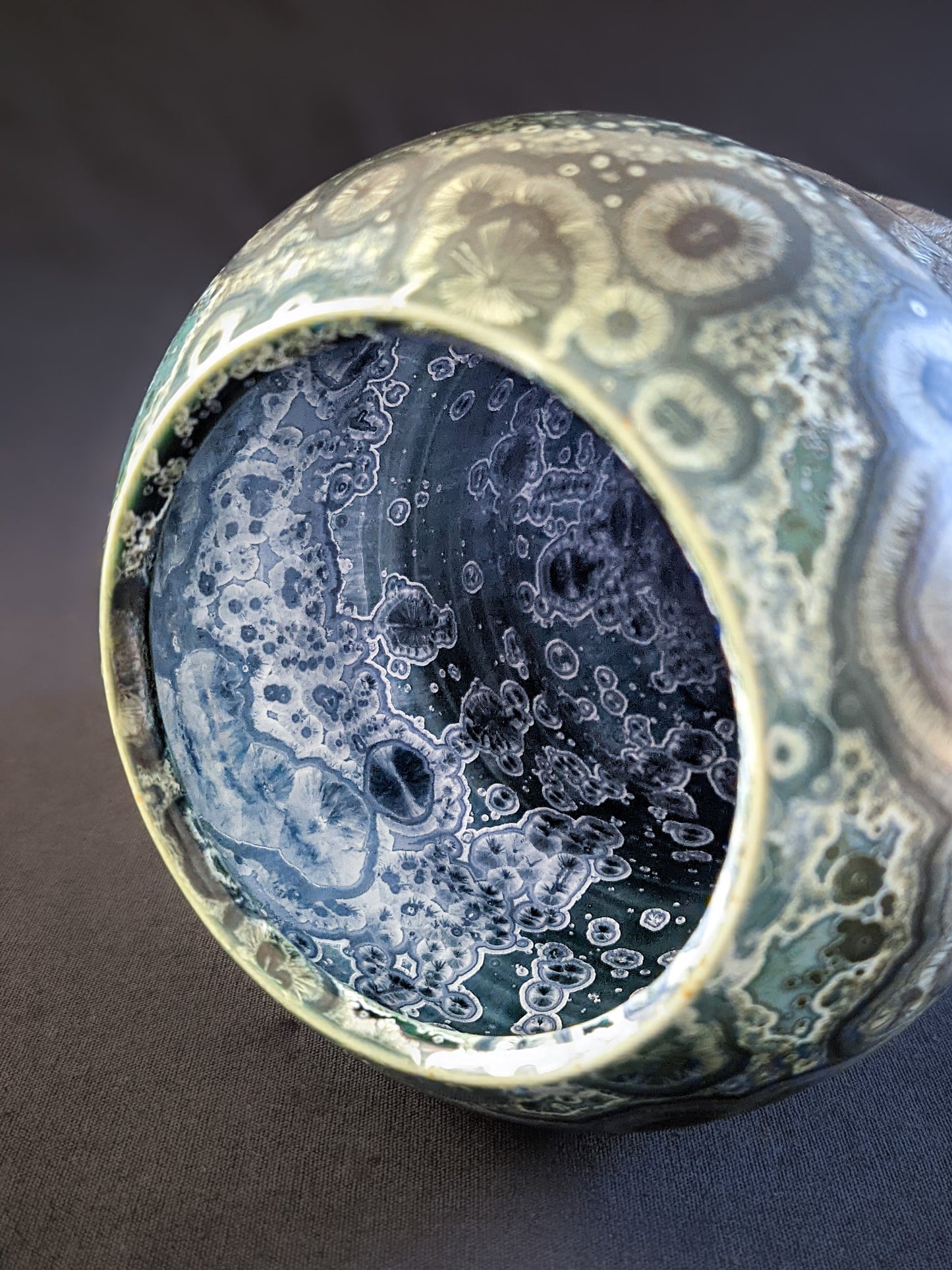Overhead shot of vase’s wide opening, highlighting its organic shape and shimmering crystalline details against a blue crystallized interior.
