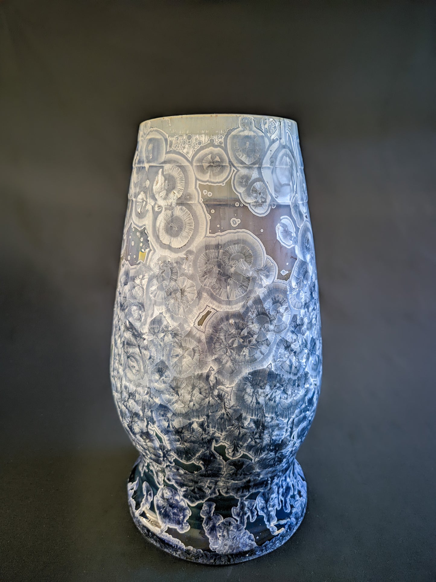 Large, sculptural vase with a wide opening, showcasing a dramatic color gradient from dark blue to light purple and white. The vase is adorned with overcrystallized blue crystals with white rings, creating an artistic texture.